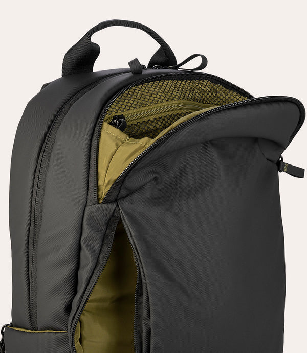 Mochila negra con compartimento principal abierto y forro interior verde oliva.