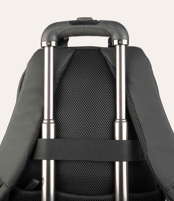 Primer plano de una mochila negra con asa telescópica y espalda de malla.