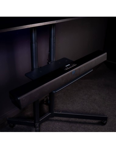 Barra de sonido negra sobre un soporte negro debajo de una mesa.