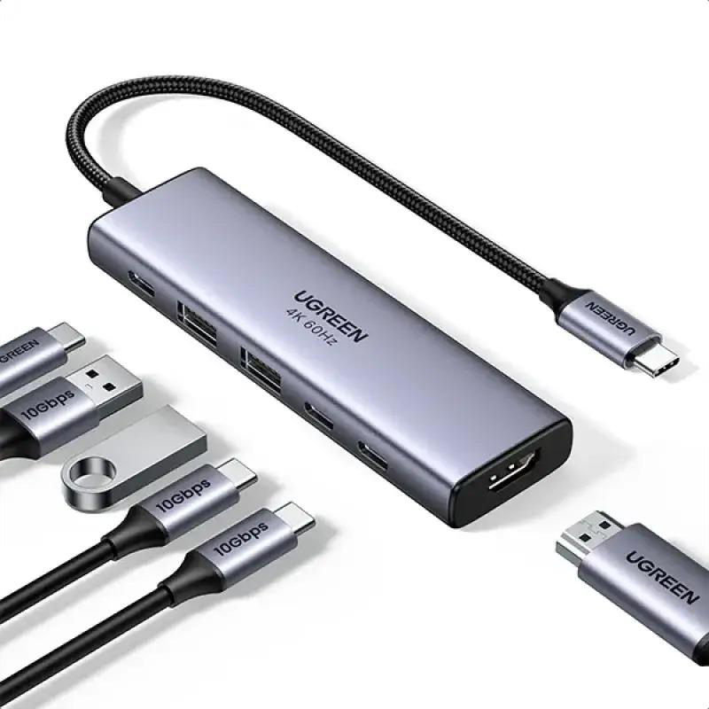 Grauer USB-C-Hub mit mehreren Anschlüssen, Kabeln und Adaptern auf weißem Hintergrund.