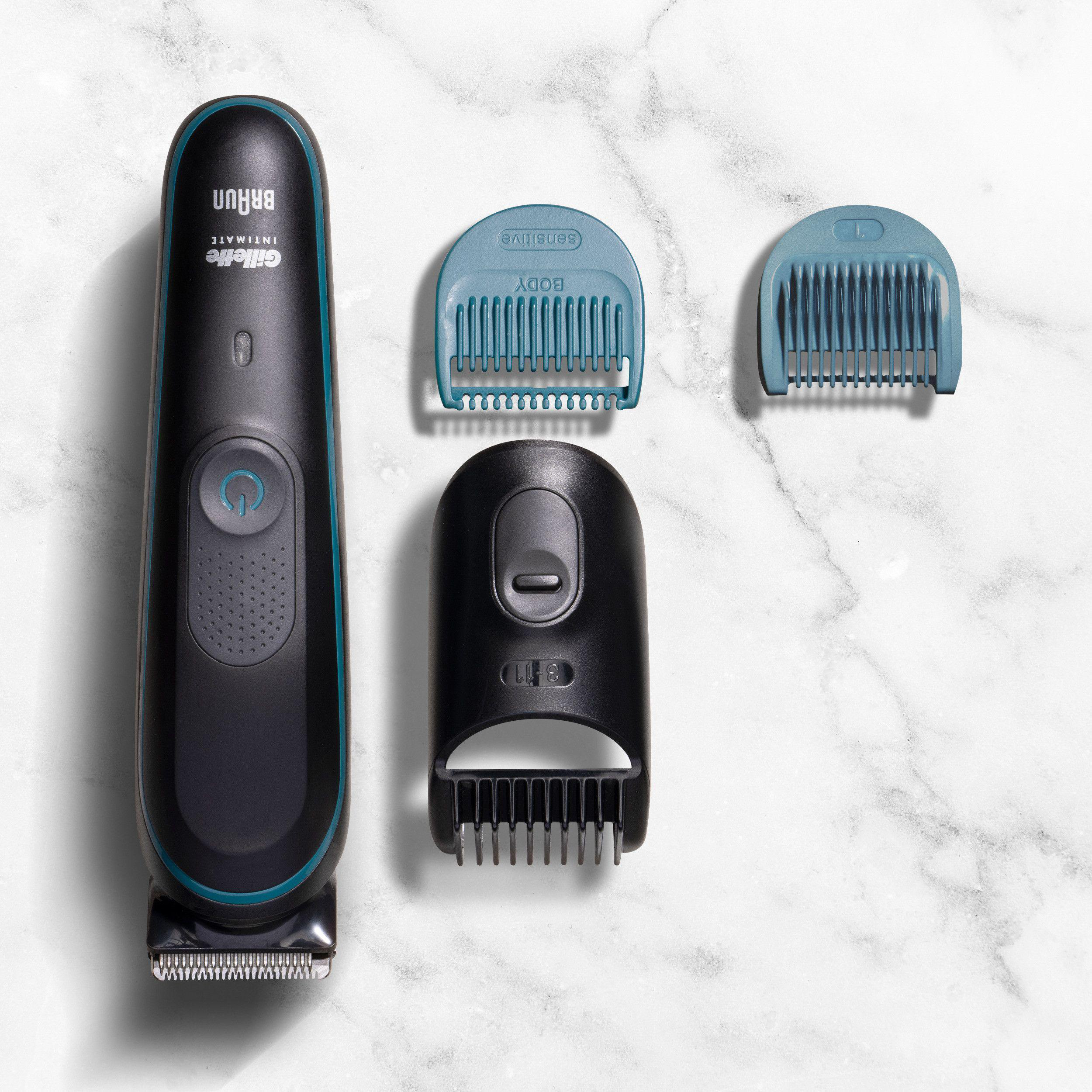 Ein schwarzer Trimmer mit blauen Akzenten und drei Aufsätzen auf Marmor.