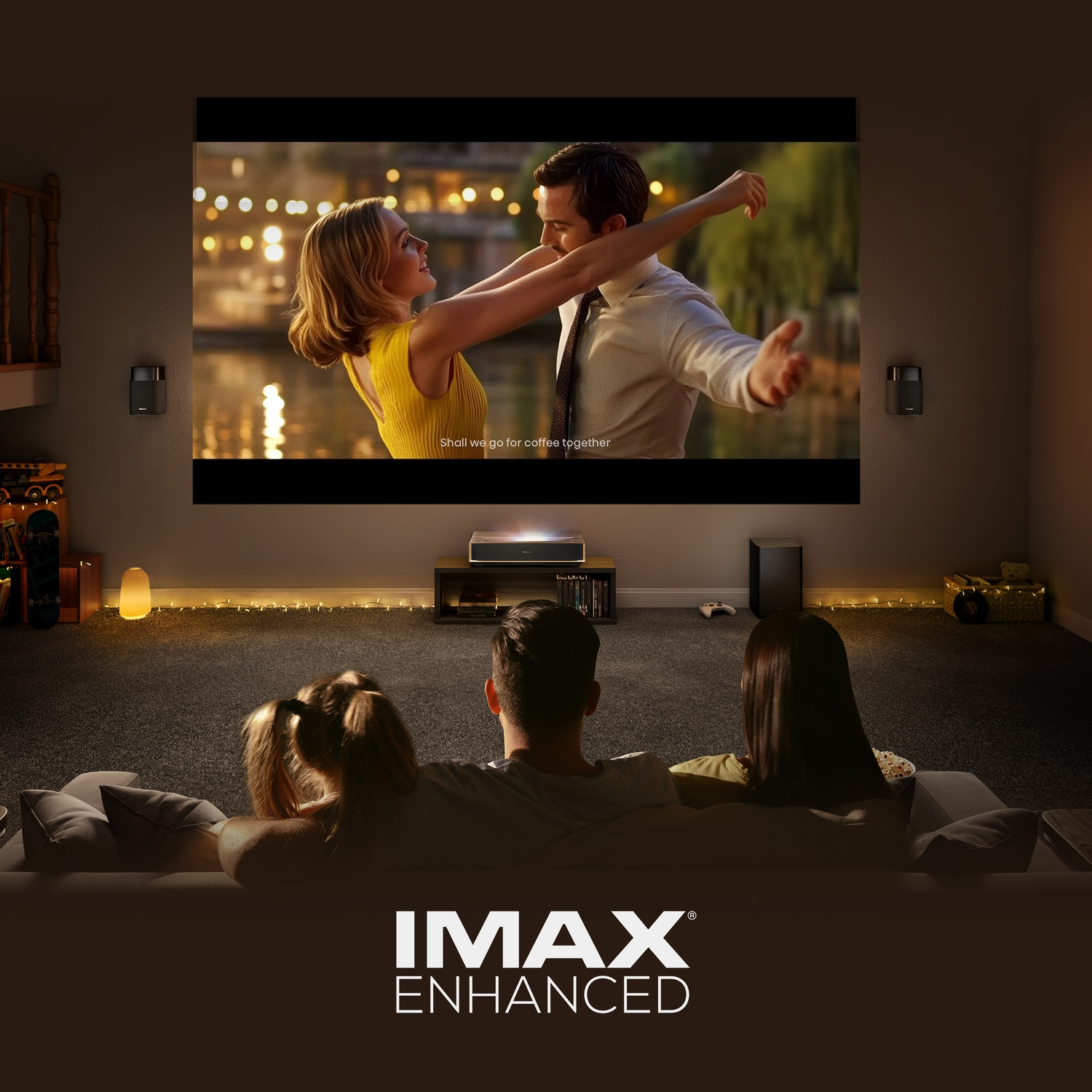 Persone guardano film su schermo proiettore con logo IMAX Enhanced.