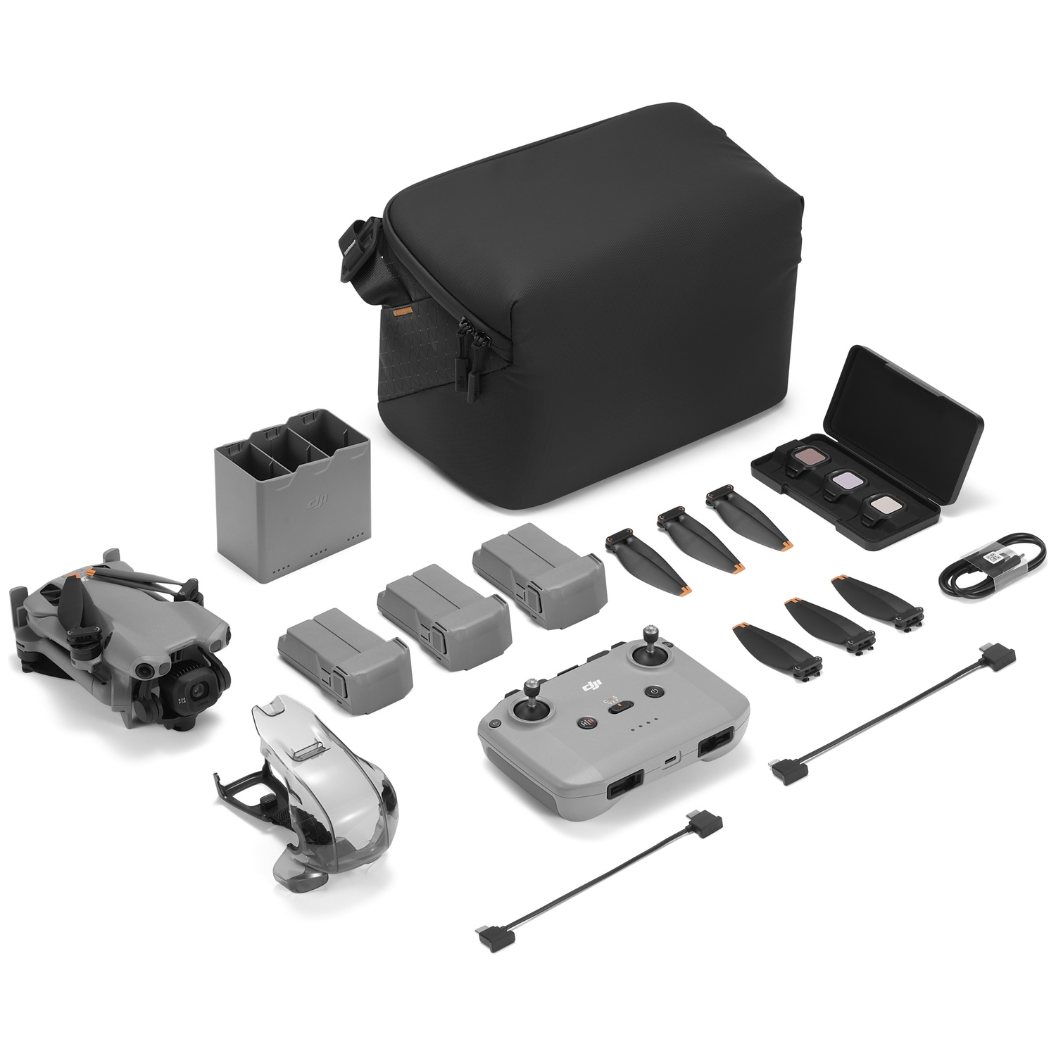 Gray DJI drone kit with accessories: drone, remote, batteries, bag, propellers, cables, filters.