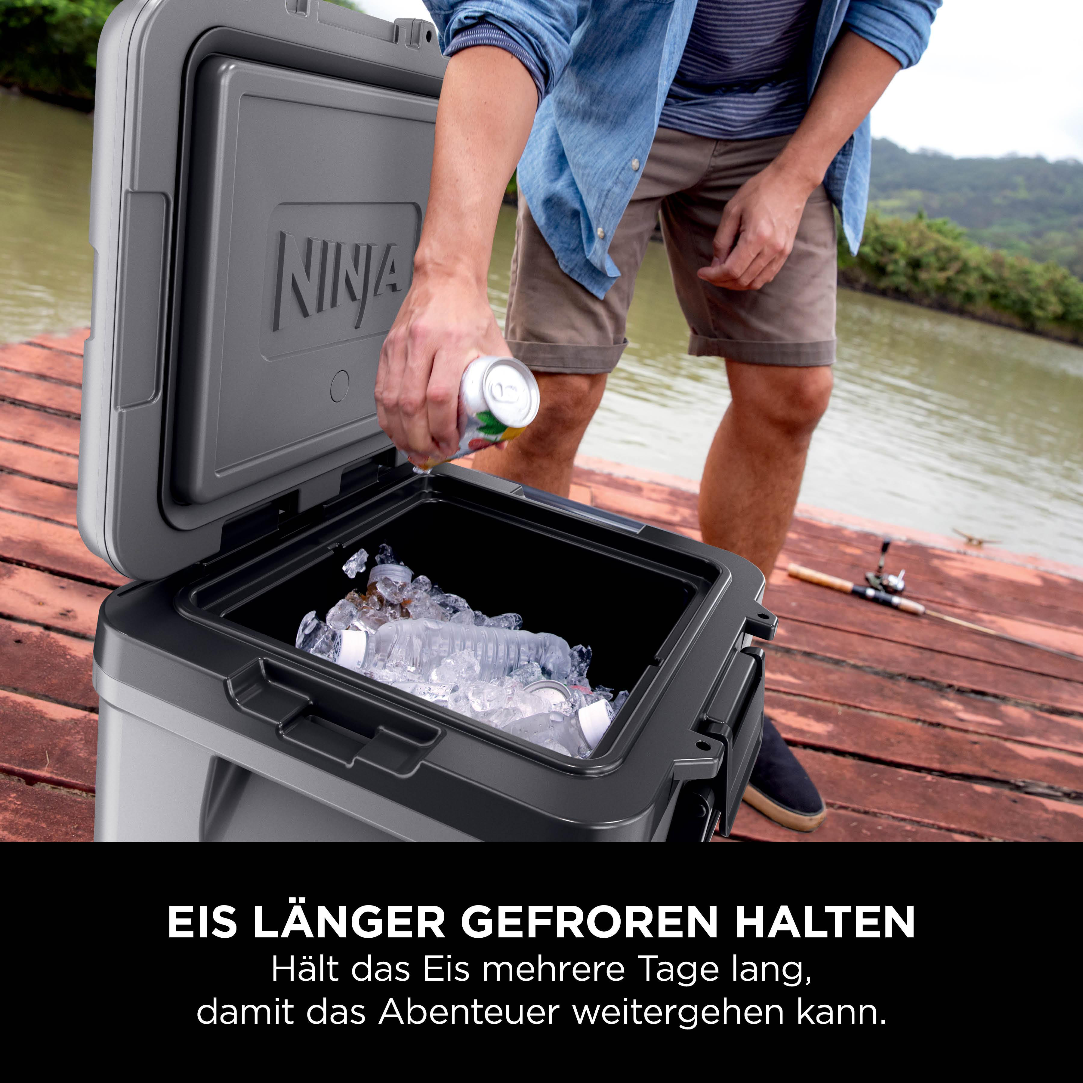 Mann legt Getränkedose in Kühlbox mit Eis. Außenansicht mit See und Natur.