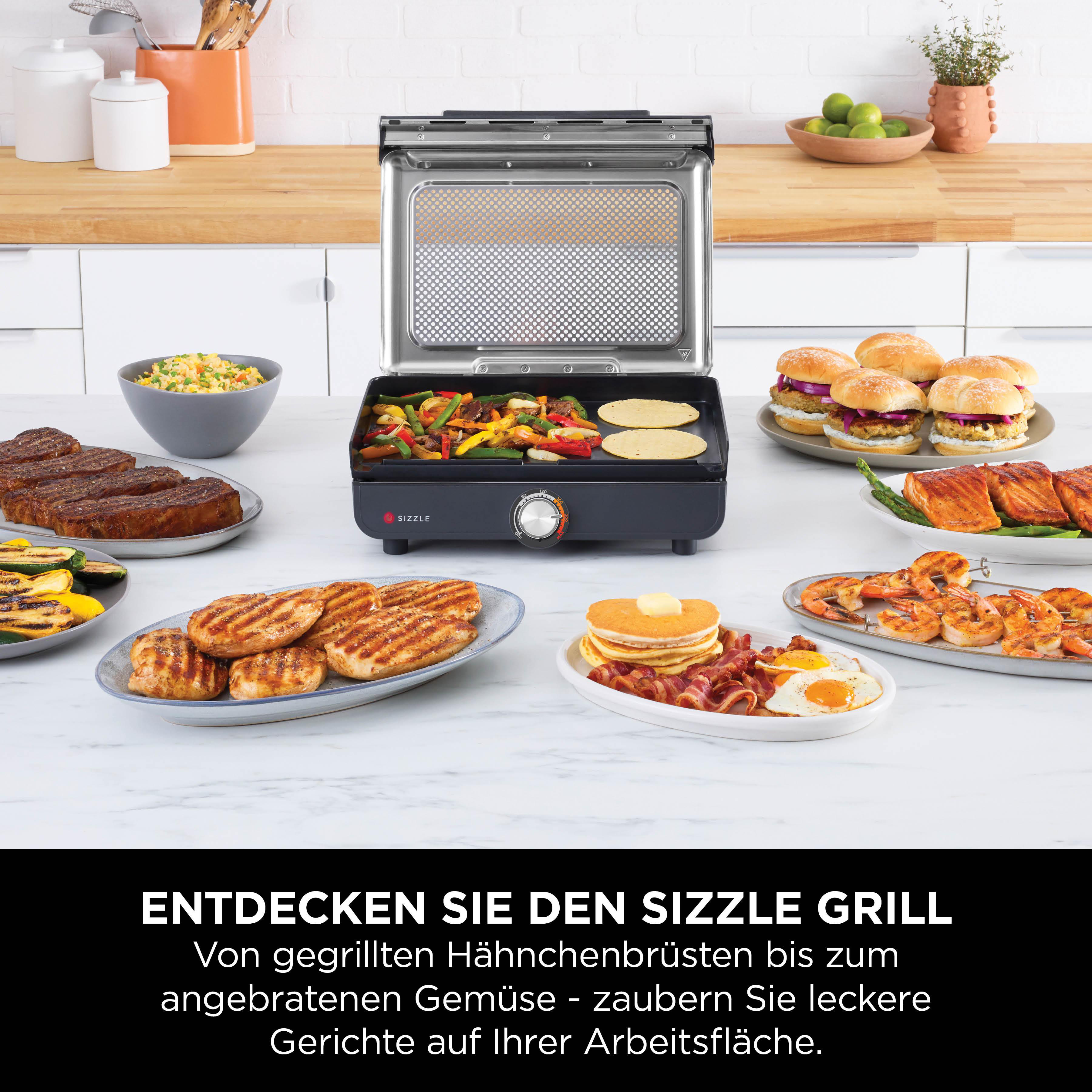 Ein Sizzle Grill mit verschiedenen Speisen wie Steaks, Burger, Lachs, Garnelen und Pfannkuchen.