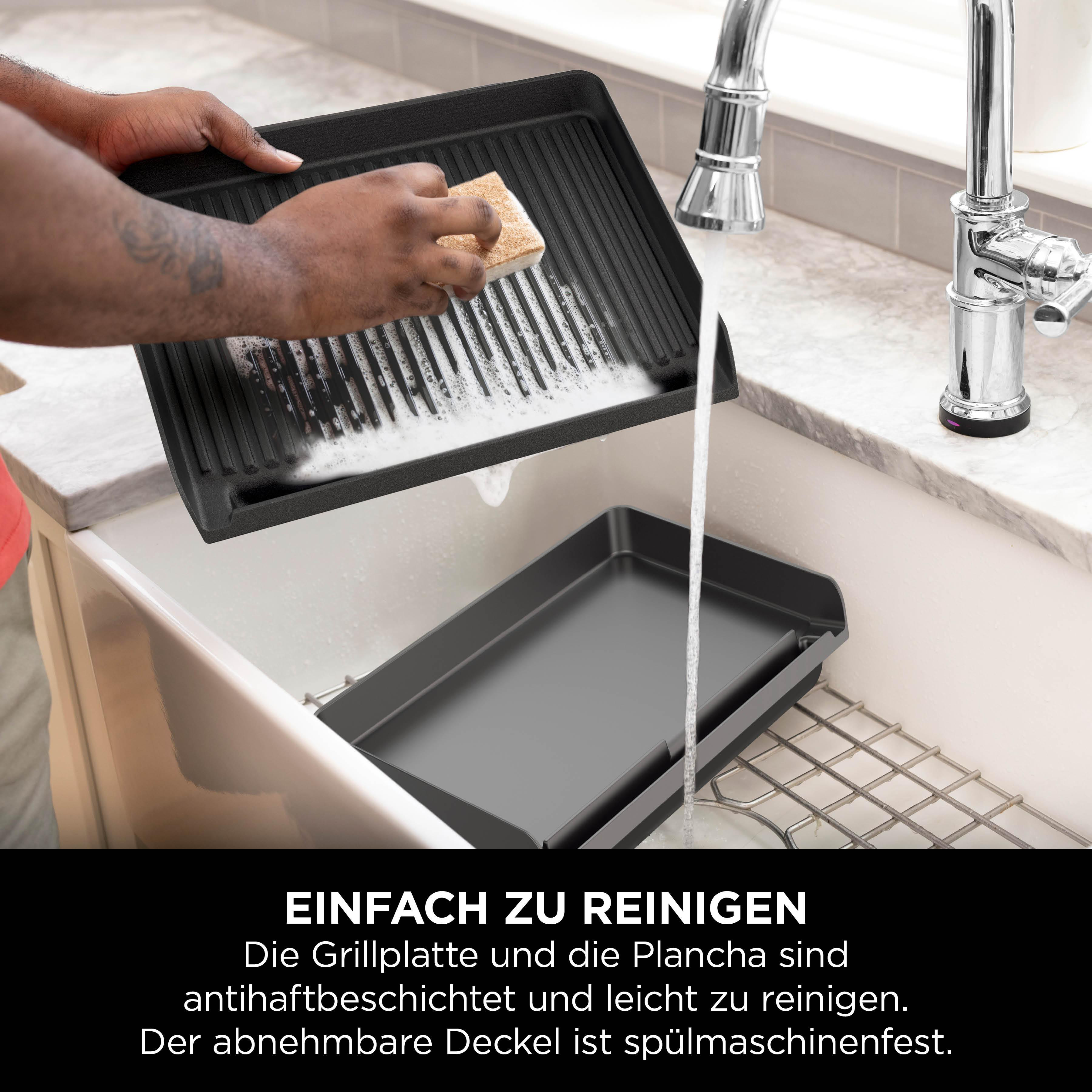 Person reinigt Grillplatte mit Schwamm und Wasser in der Spüle.