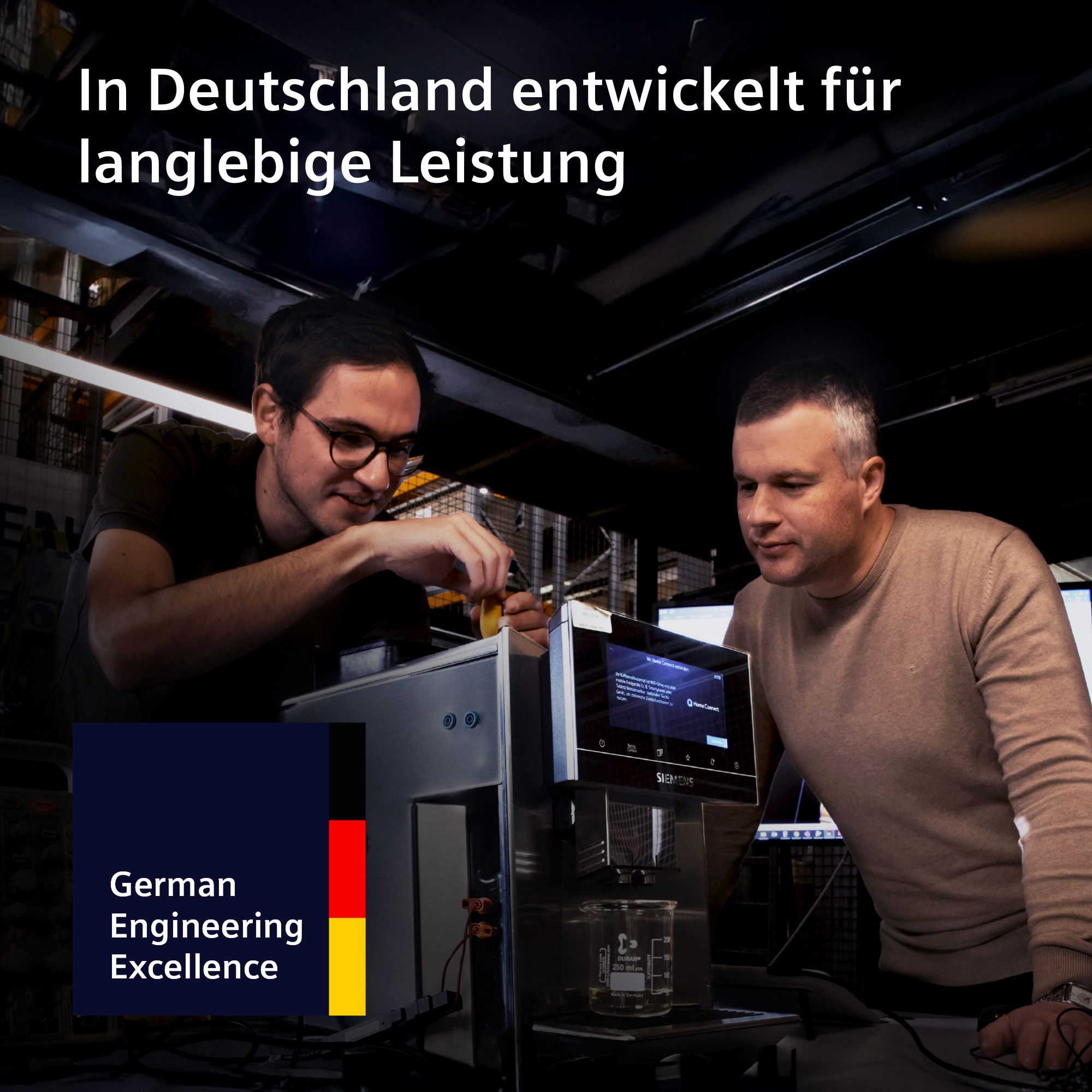 Männer arbeiten an einer Maschine mit Siemens-Logo und deutschem "German Engineering Excellence"-Banner.