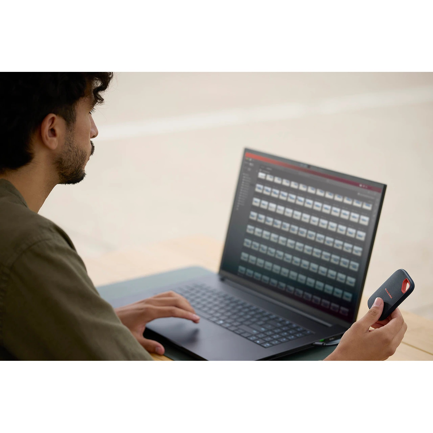 Uomo con laptop e disco esterno all'aperto