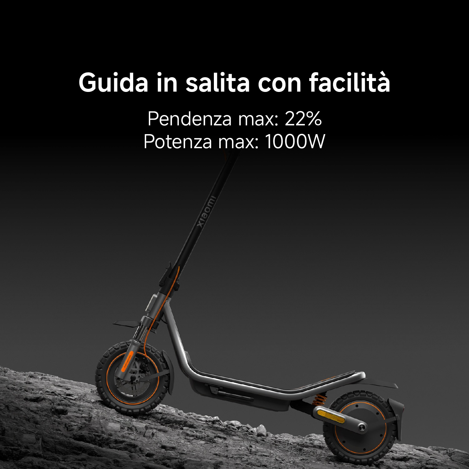 Un monopattino elettrico Xiaomi grigio con accenti arancioni su terreno roccioso.