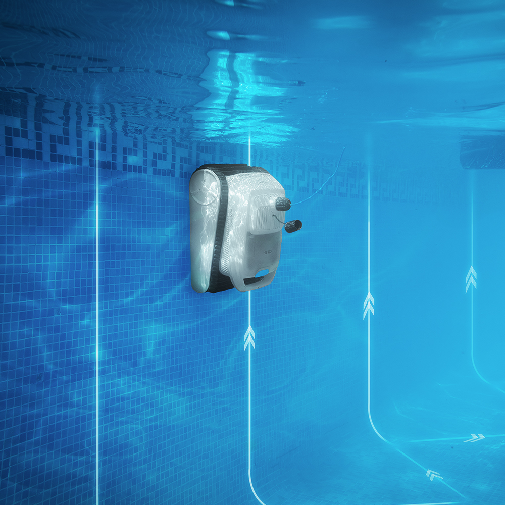 Un robot limpiador de piscinas blanco limpia la pared de baldosas azules bajo el agua.
