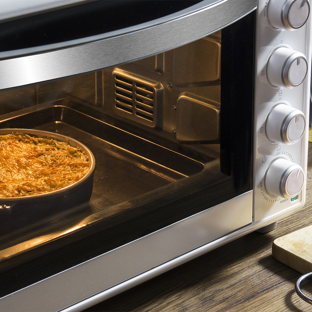 Un gratinado con costra dorada horneándose dentro de un horno abierto en una rejilla.