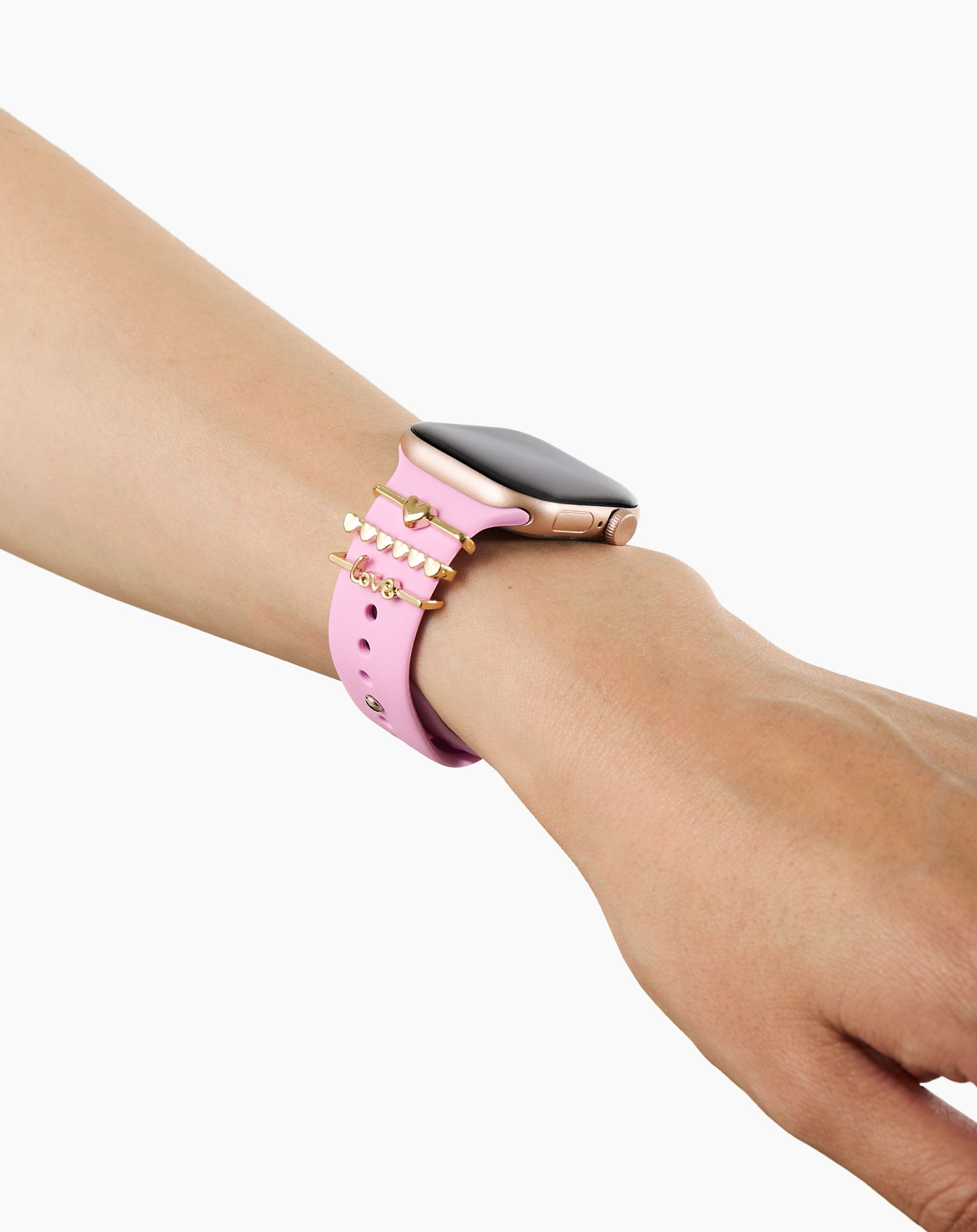 Goldfarbene Anhänger mit Herzen und dem Wort „Love“ auf einem rosafarbenen Armband einer Smartwatch.