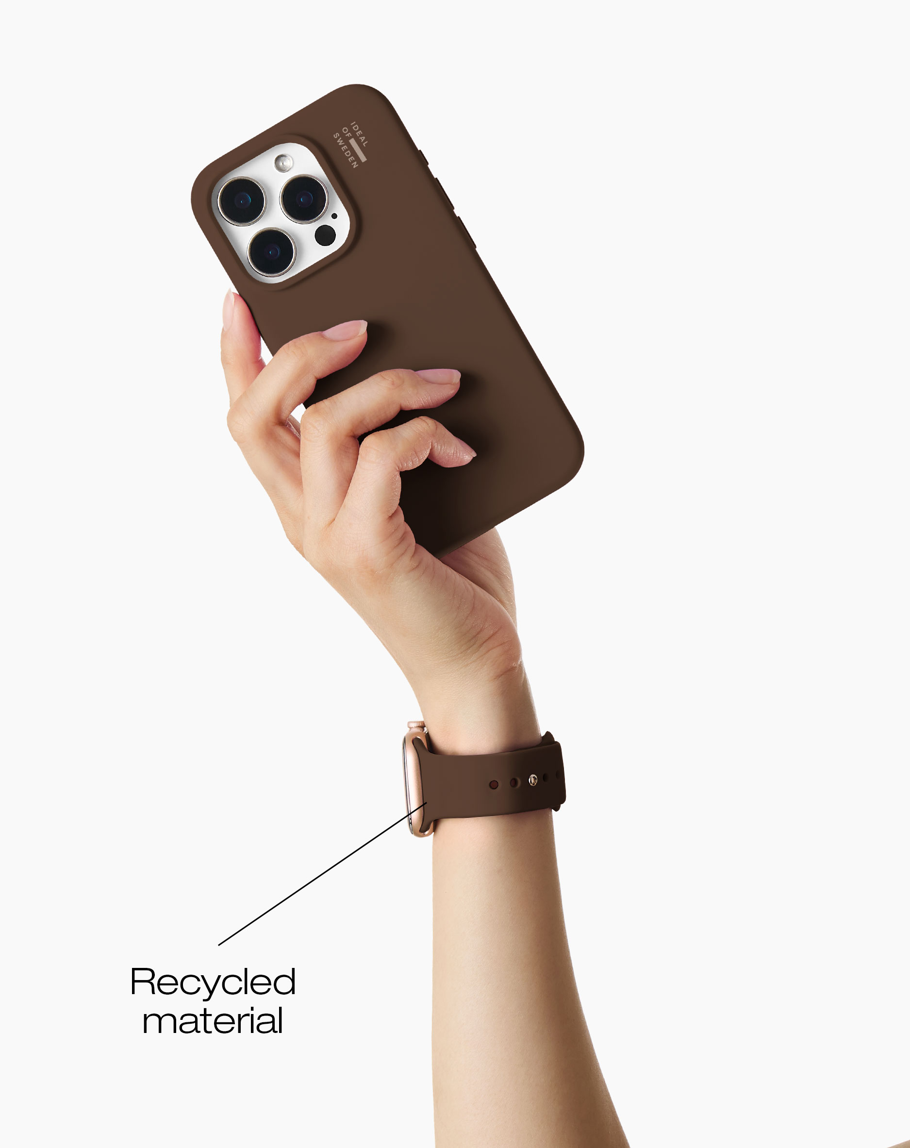Eine Hand hält ein braunes Handy mit drei Kameras. Ein Armband ist zu sehen.