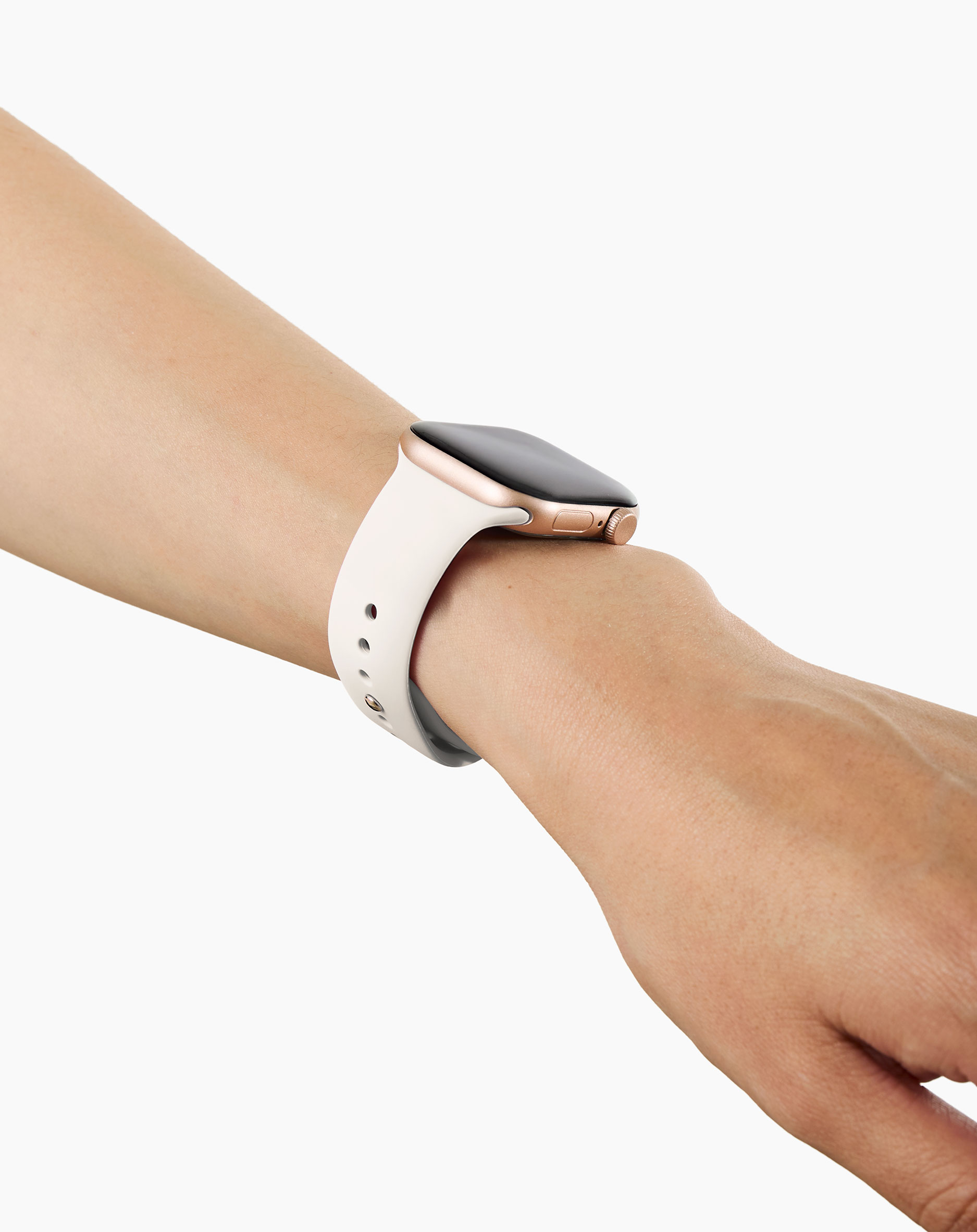 Eine weiße Smartwatch mit goldenem Gehäuse an einem Arm.