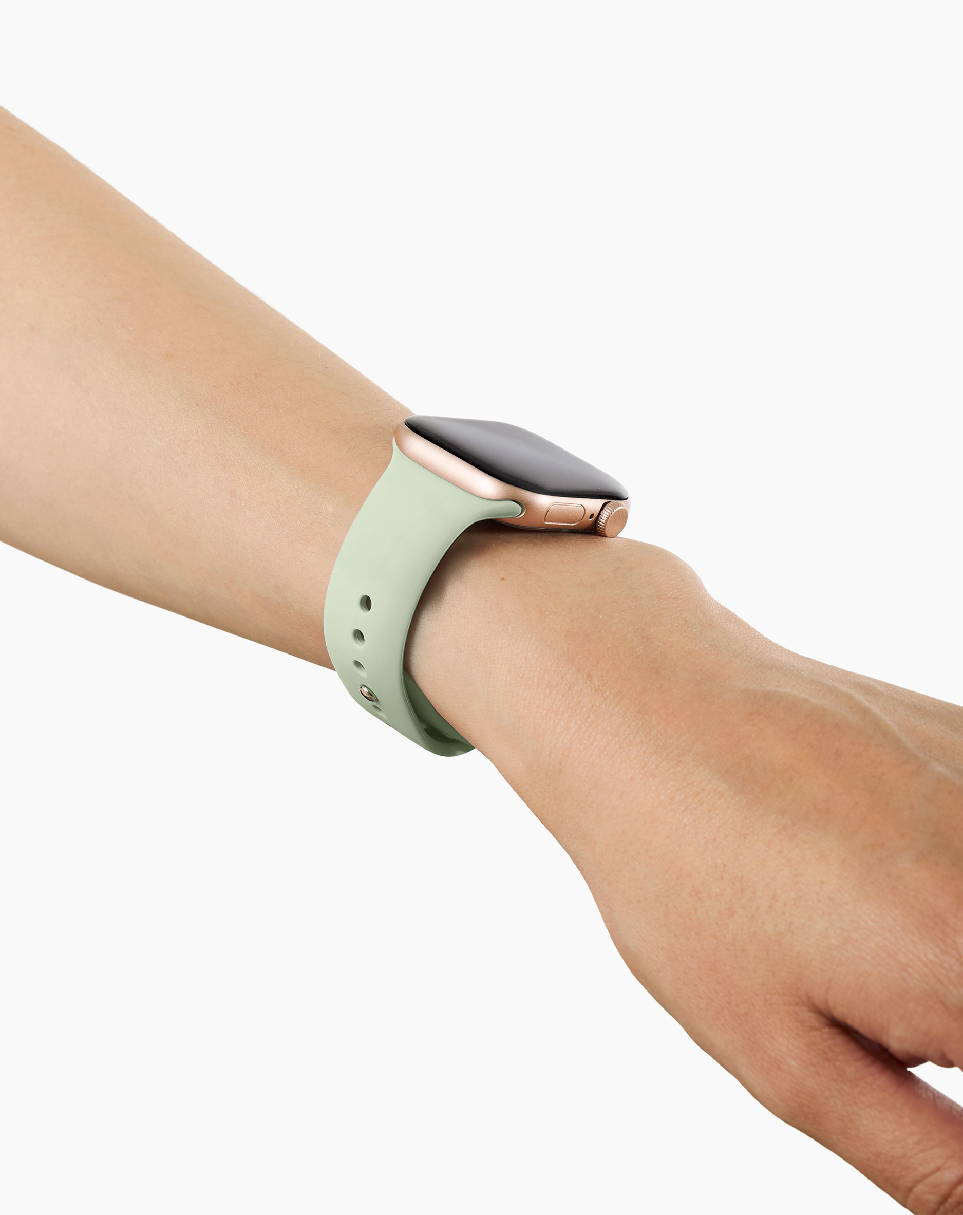 Eine hellgrüne Smartwatch mit goldenem Gehäuse an einem Arm.