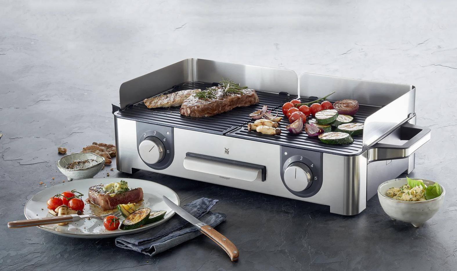 Edler Tischgrill mit Steaks, Gemüse und Beilagen.