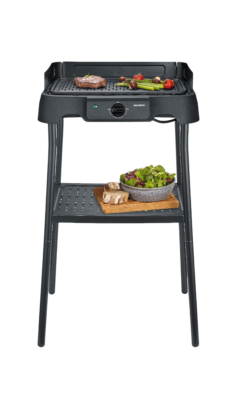 Ein elektrischer Grill mit Steak, Spargel, Pilzen, Tomaten, Brot und Salat.