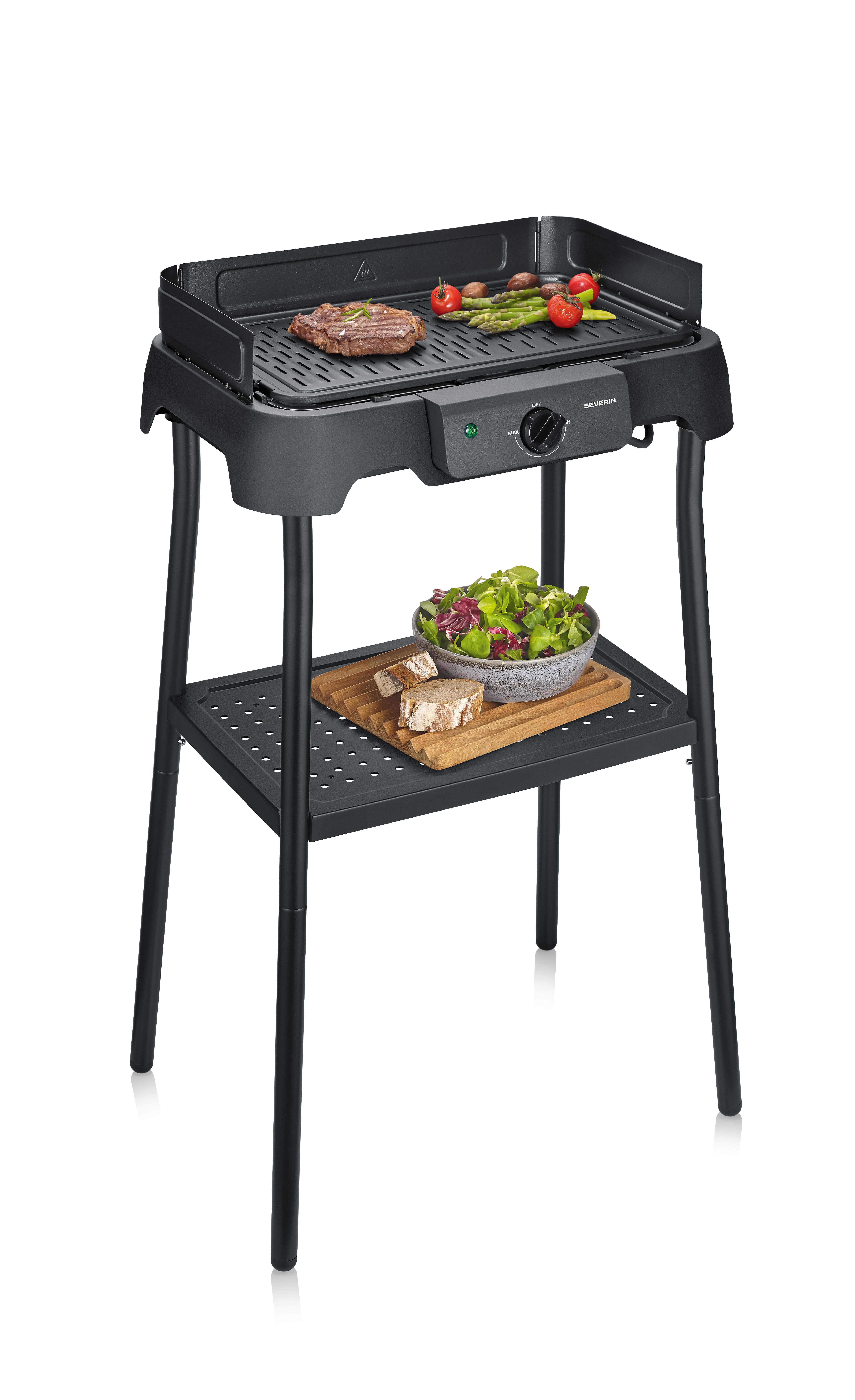 Ein schwarzer Elektrogrill mit Steak, Spargel und Tomaten. Unten ein Salat.