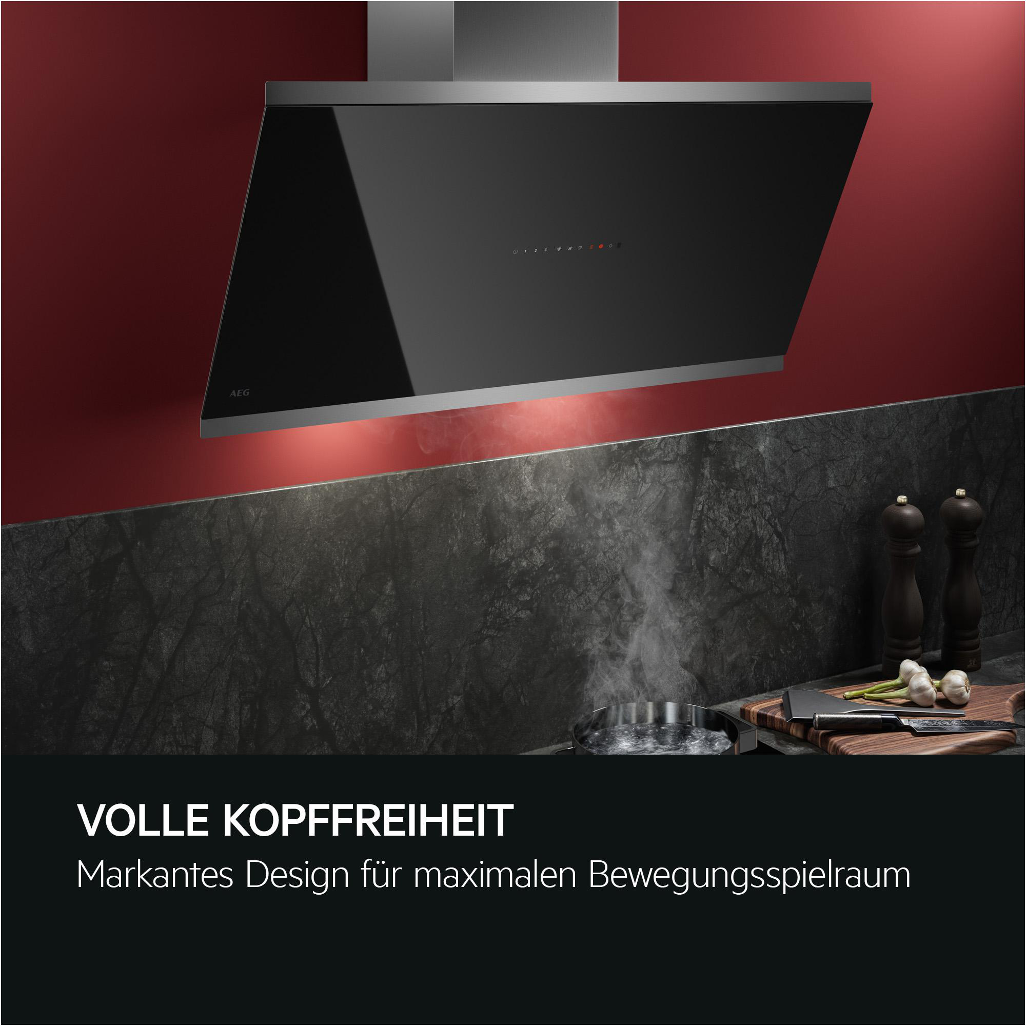 Moderne Dunstabzugshaube über Kochutensilien, mit Dampf.