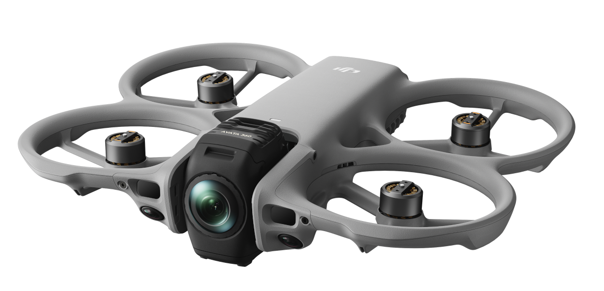 Szara dron z czterema śmigłami i kamerą na czarnym tle.