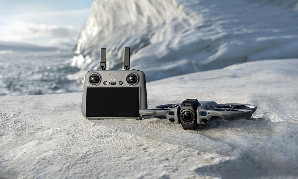 Dron i pilot na skalistym podłożu z lodowym krajobrazem.