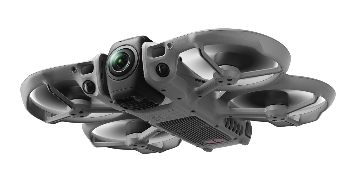 Szara dron z kamerą i śmigłami na czarnym tle.