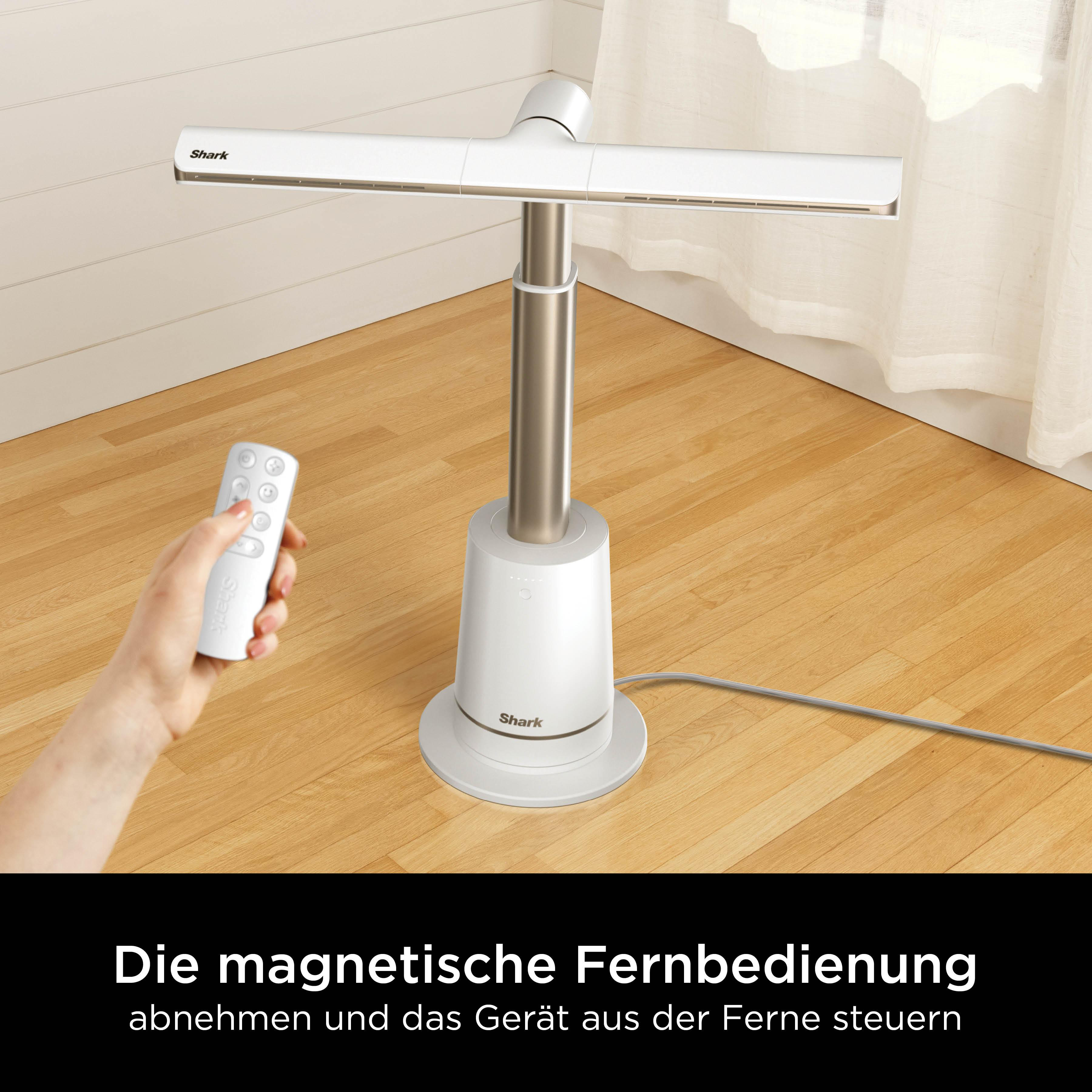 Ein weißer Standventilator mit Fernbedienung auf einem Holzboden.