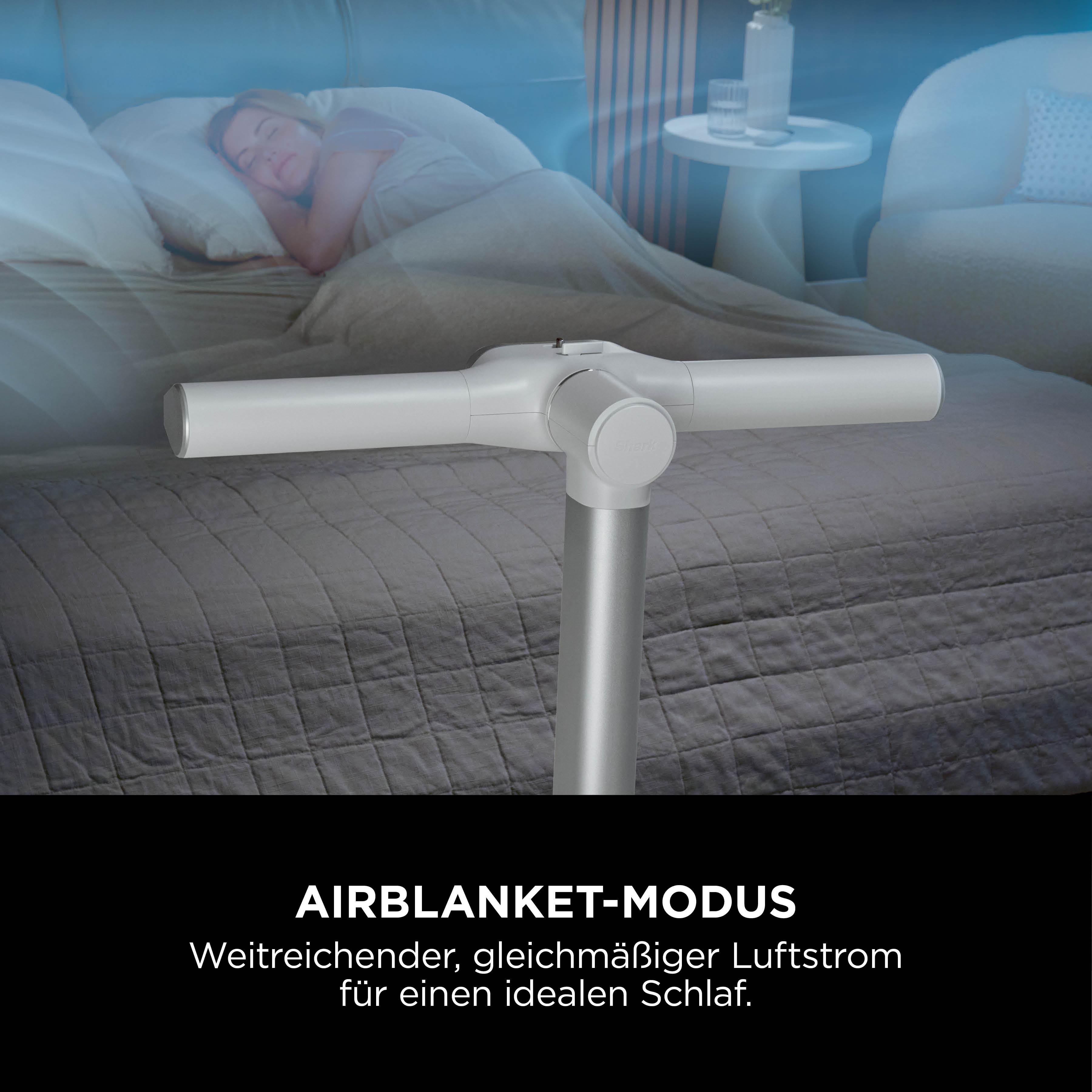 Frau schläft in einem Bett, ein weißer Luftreiniger steht davor.
