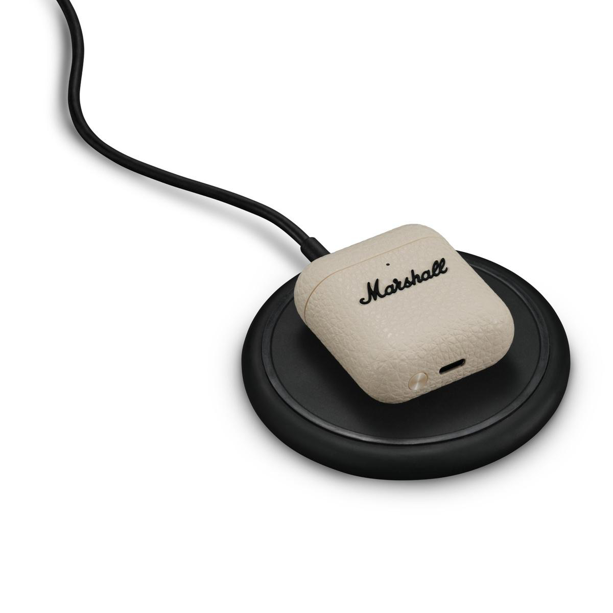 Beige Marshall-Kopfhörerhülle auf schwarzer Ladestation mit Kabel.