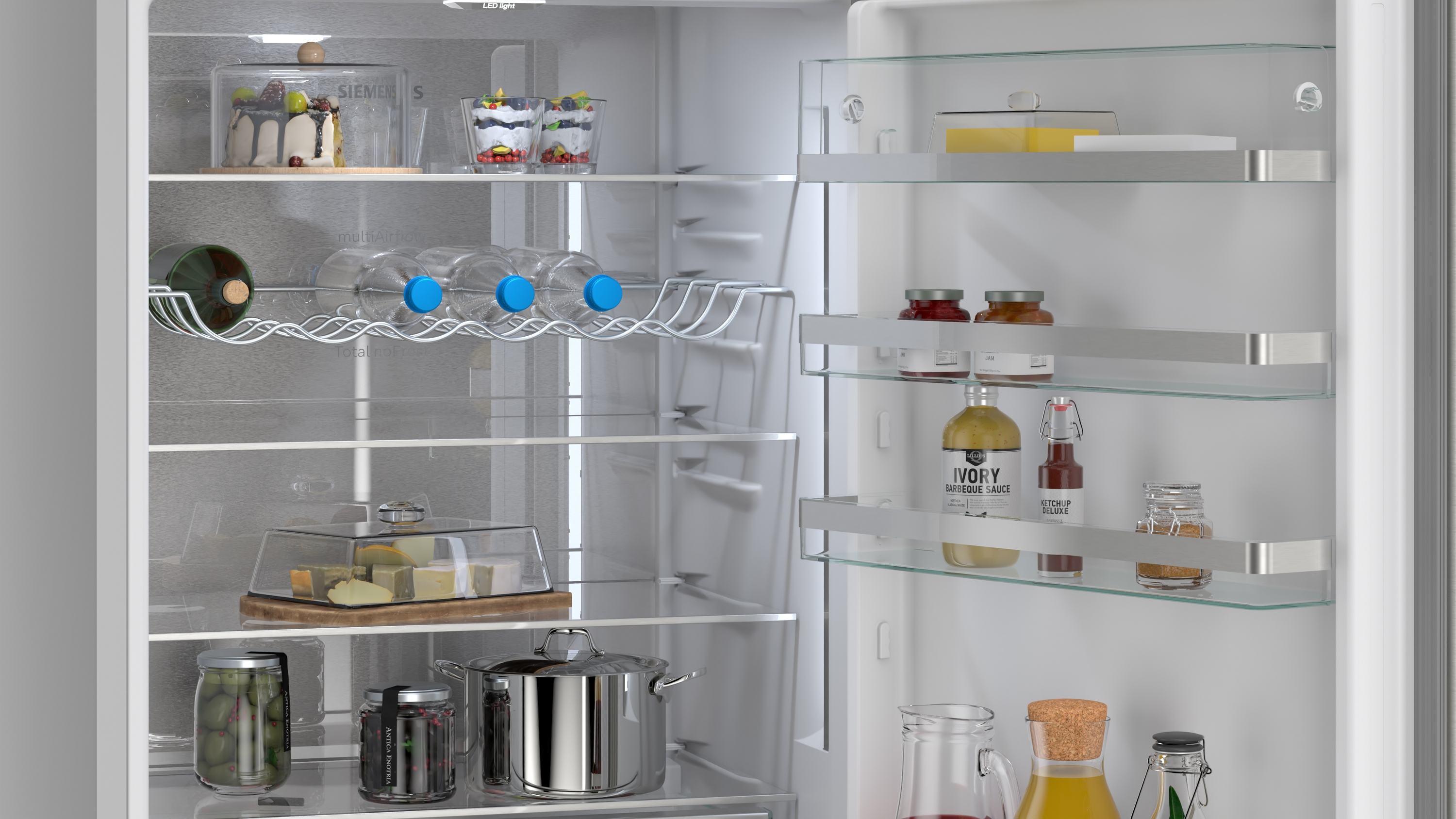 Gefüllter Kühlschrank mit Kuchen, Flaschen, Gläsern, Käse, Oliven und Töpfen.