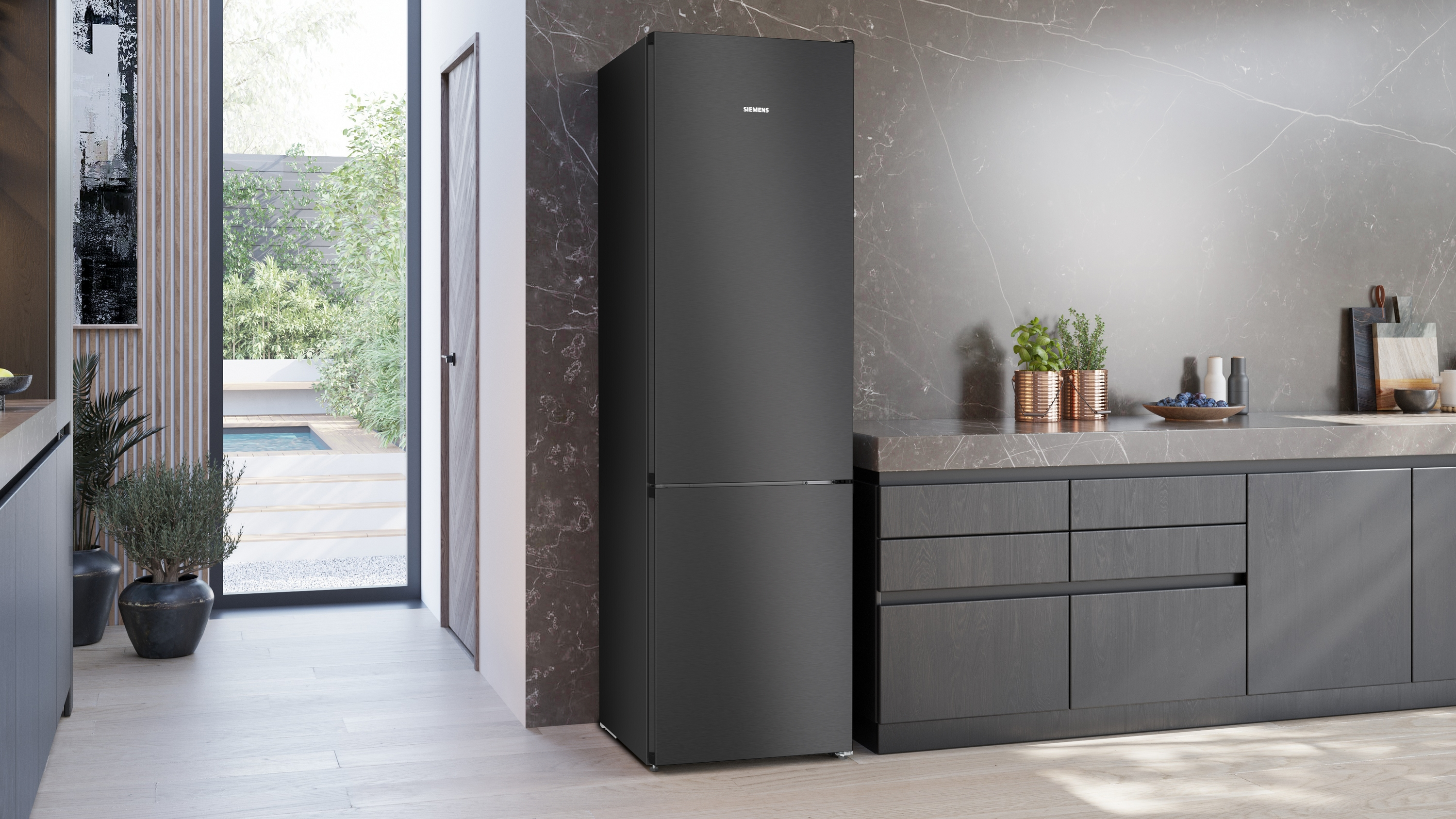 Ein schwarzer Siemens-Kühlschrank steht in einer modernen Küche neben Arbeitsplatten.