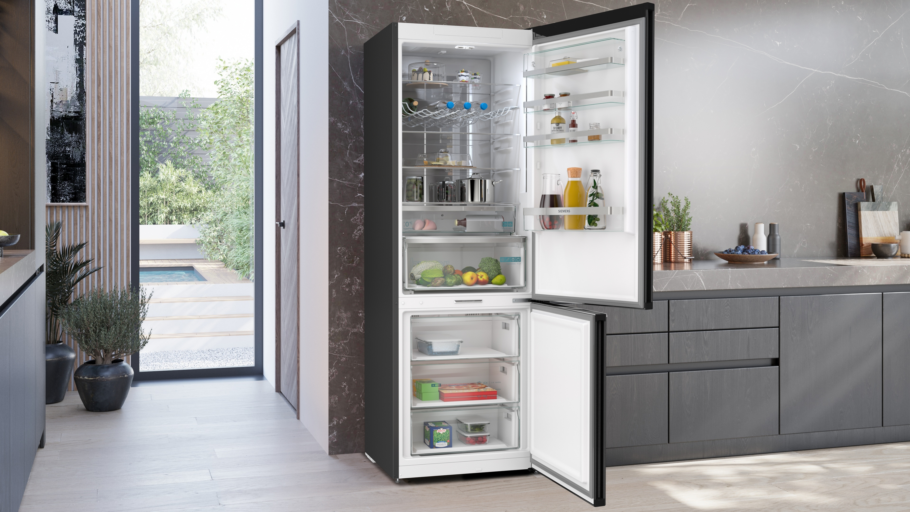 Ein offener Kühlschrank in einer modernen Küche mit Obst, Gemüse und Getränken.