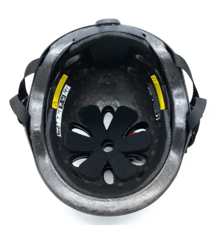 Wnętrze czarnego kasku z wyściółką i paskami. Widoczne białe i żółte naklejki.