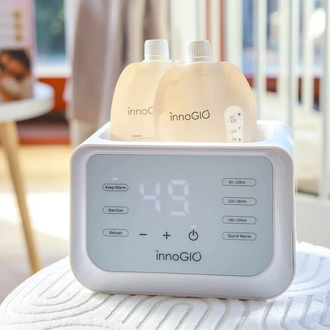 Biały podgrzewacz do butelek z dwoma woreczkami płynu.