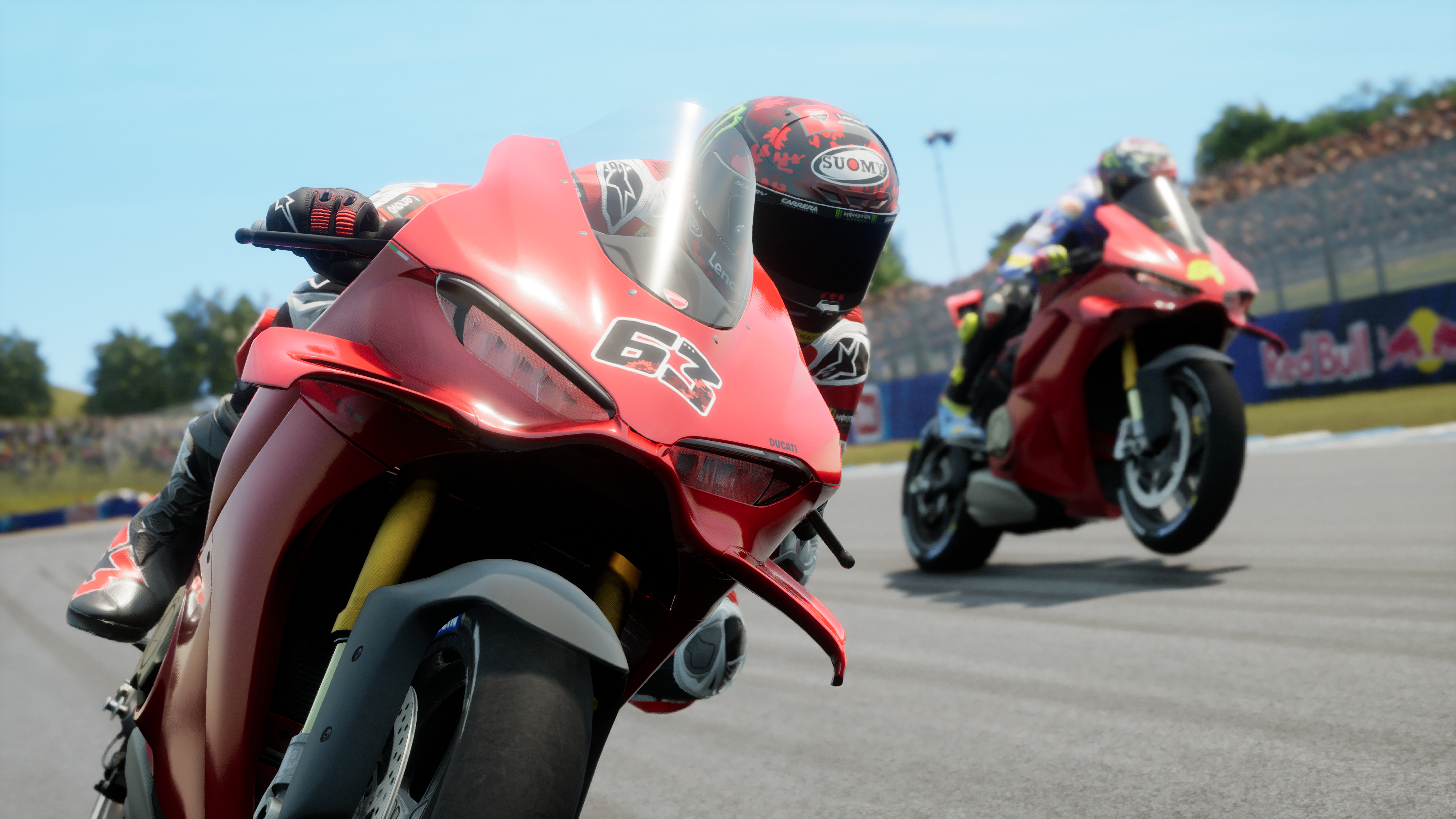 Deux motos Ducati courent sur une piste. La moto de devant est rouge avec le numéro 63.