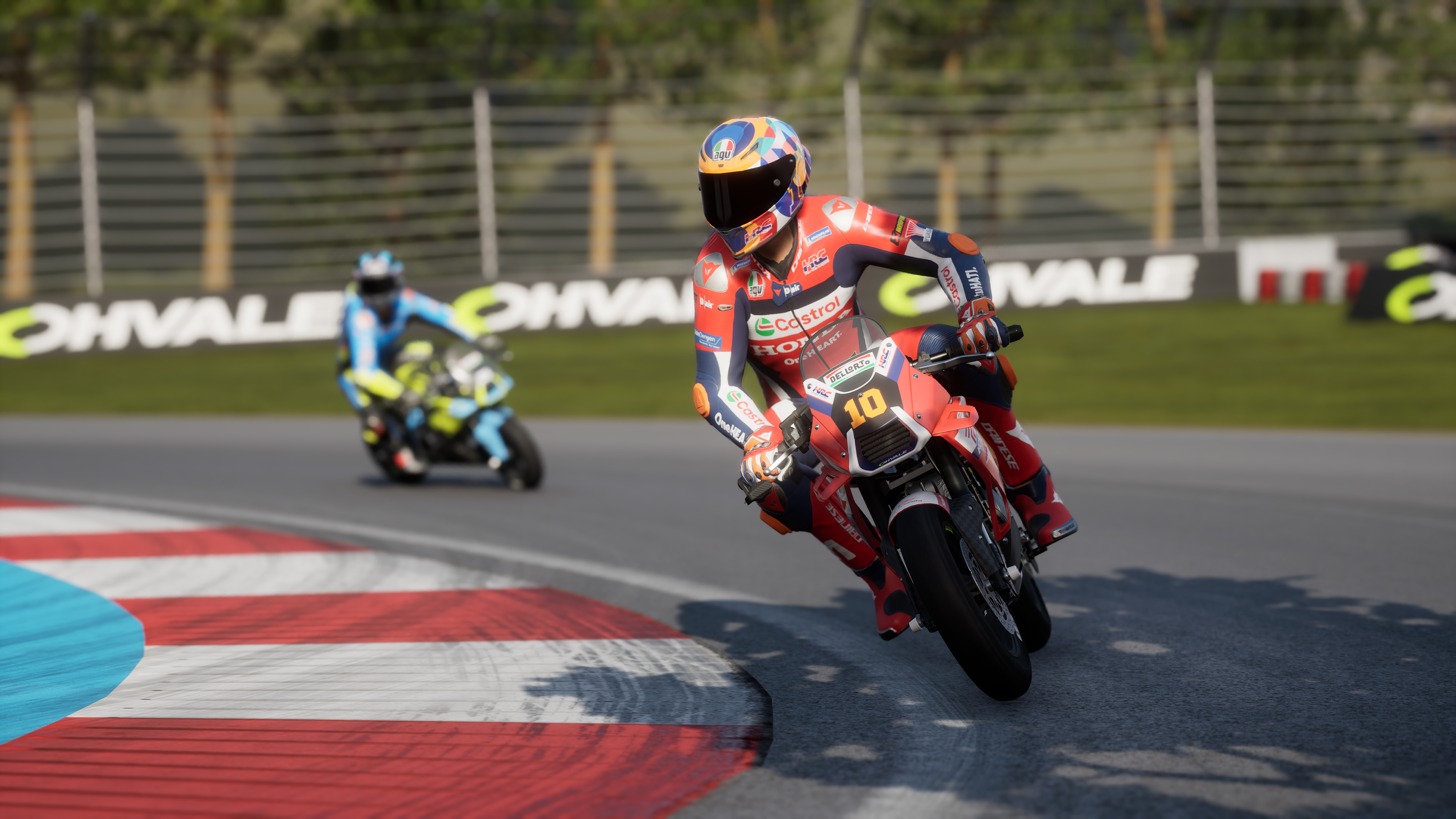 Un coureur en rouge conduit une moto rouge sur un circuit.