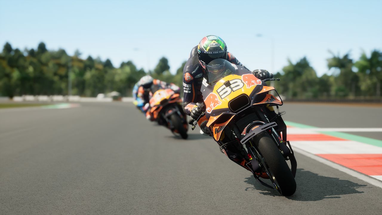 Des motocyclistes font la course sur une piste avec des arbres en arrière-plan.