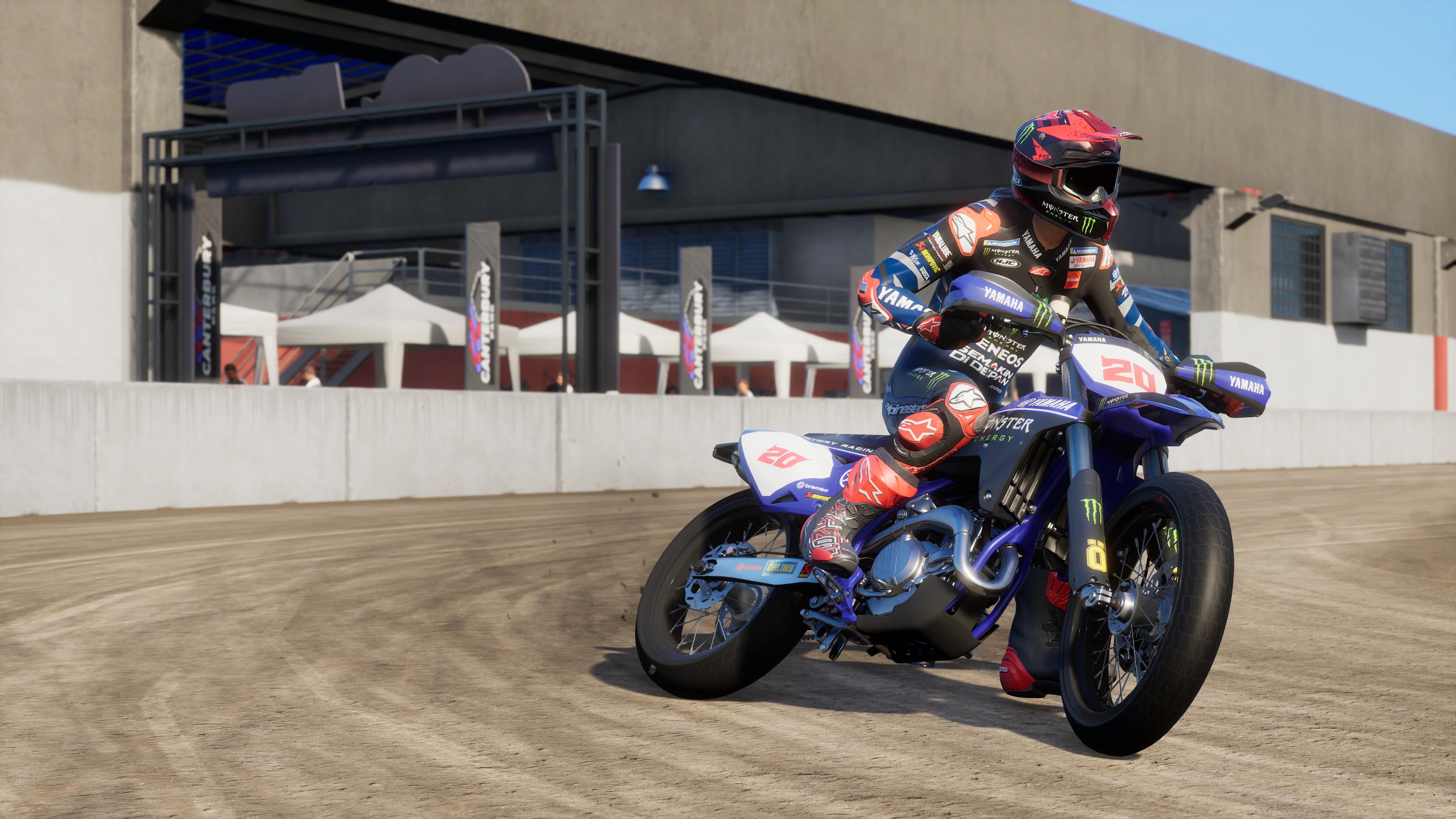 Un pilote sur une Yamaha bleue roule sur une piste en terre.