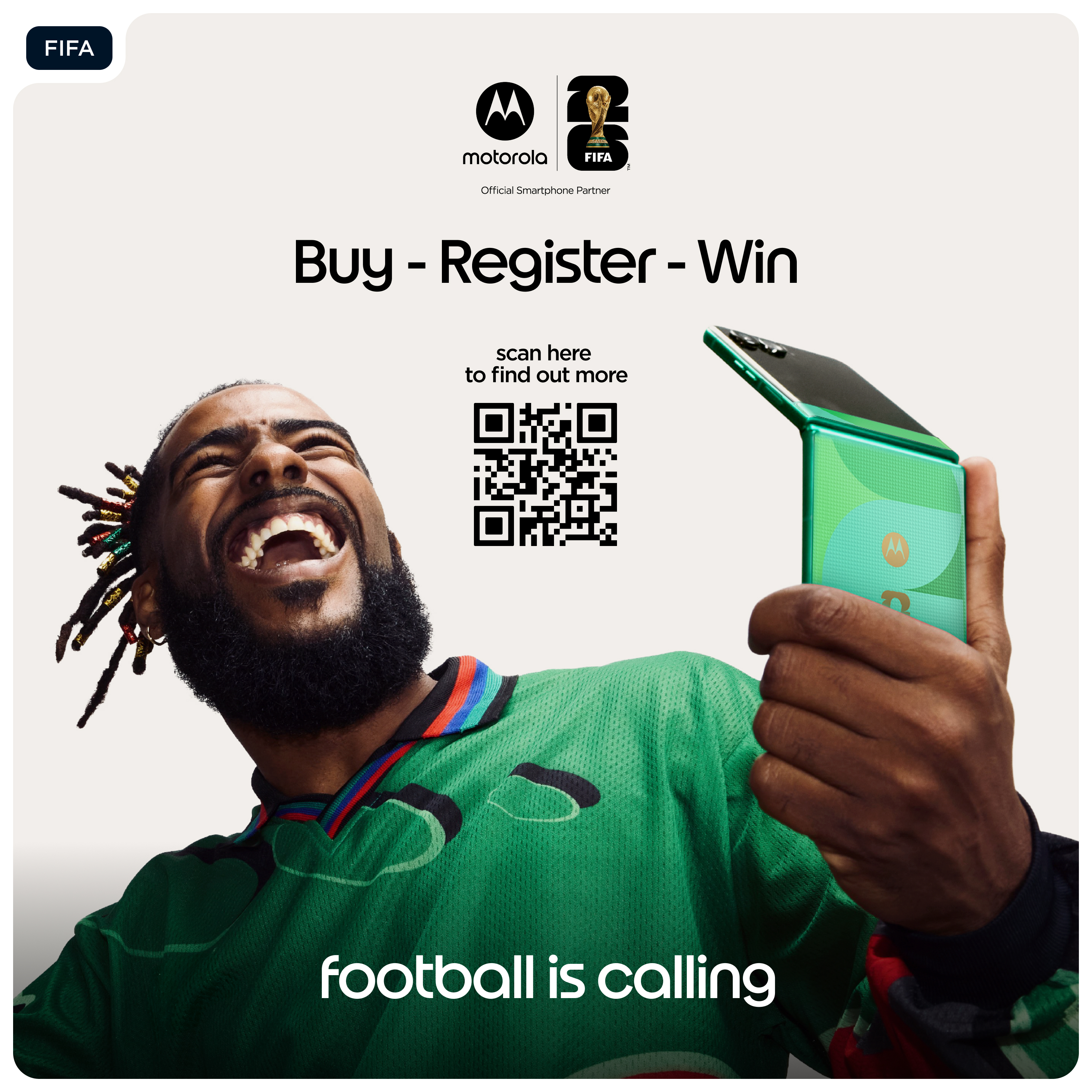Mann lacht, hält ein grünes Klapphandy. FIFA & Motorola Logos. 'Fußball ruft.'