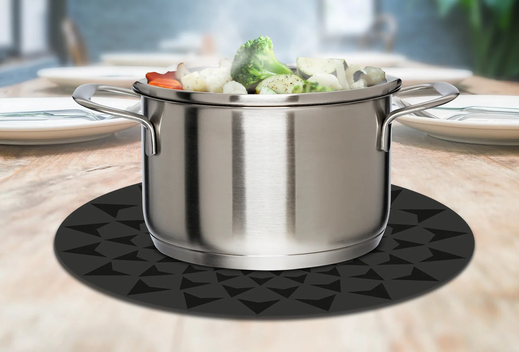 Stalowa parowa z warzywami na stole.