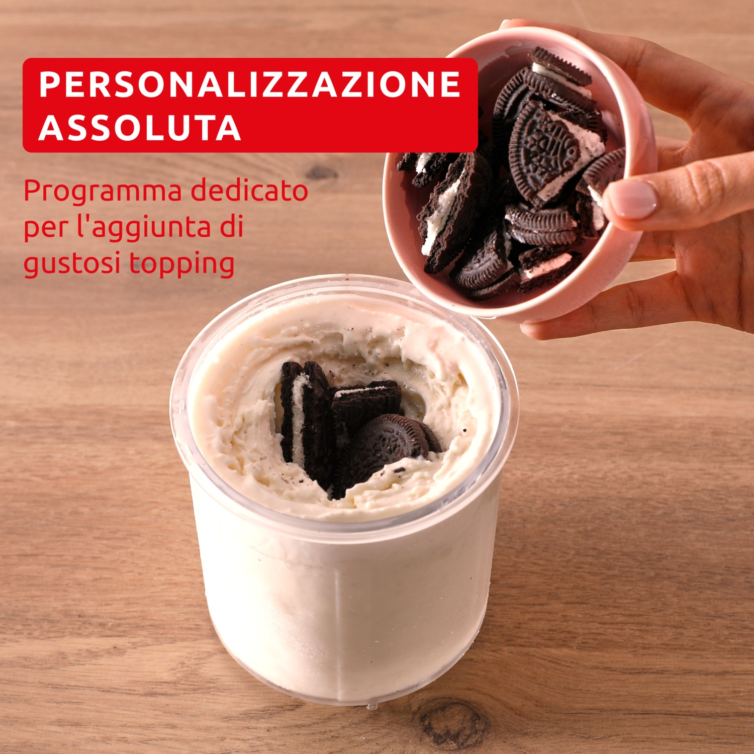 Una mano aggiunge biscotti rotti in una ciotola di gelato.