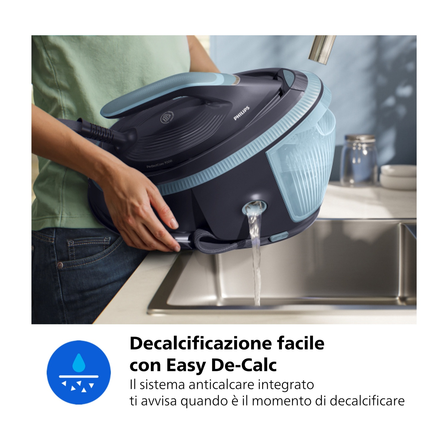 Una persona versa acqua da un ferro da stiro a vapore in un lavello.