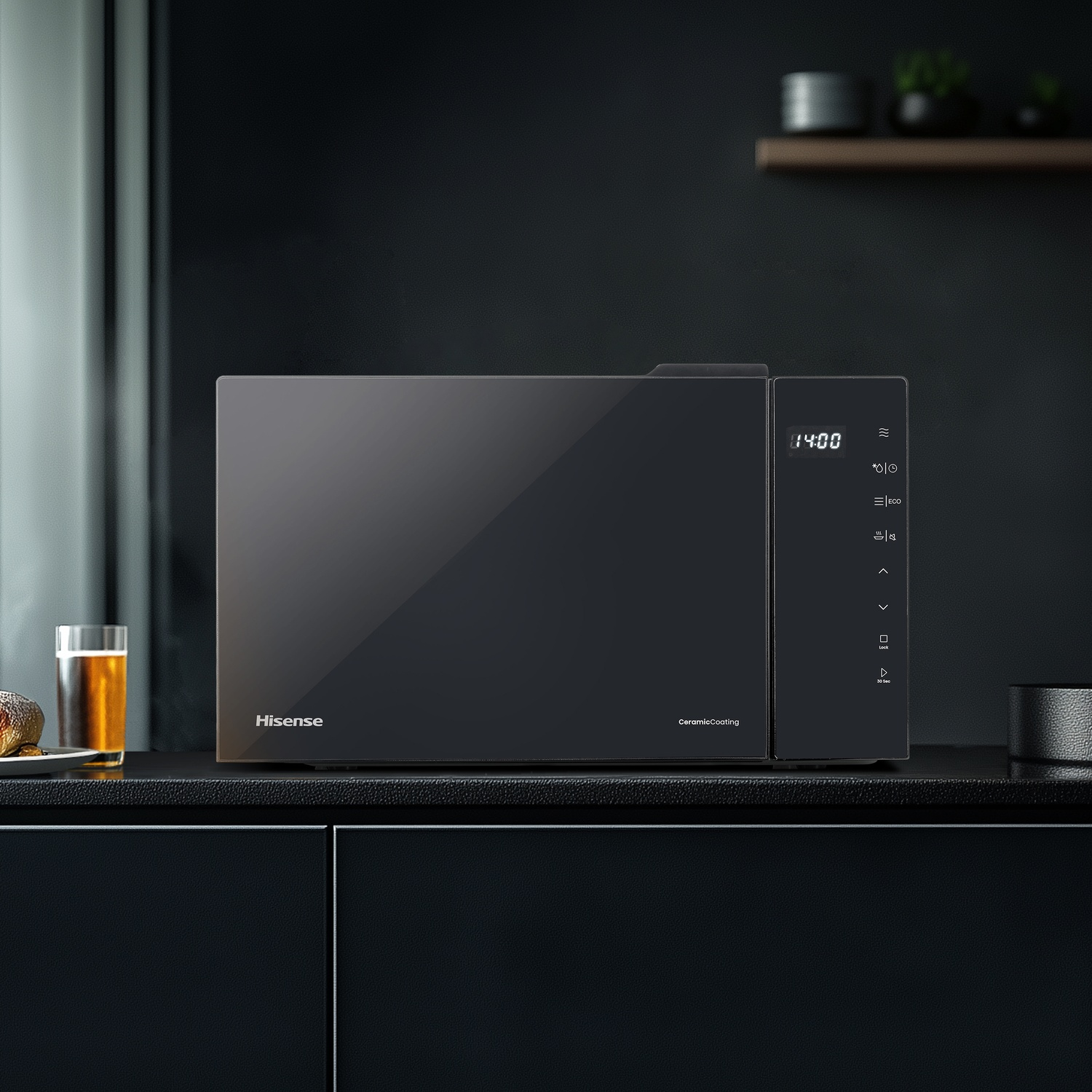 Un forno a microonde Hisense nero è posato su un piano di lavoro scuro accanto a un bicchiere di birra.