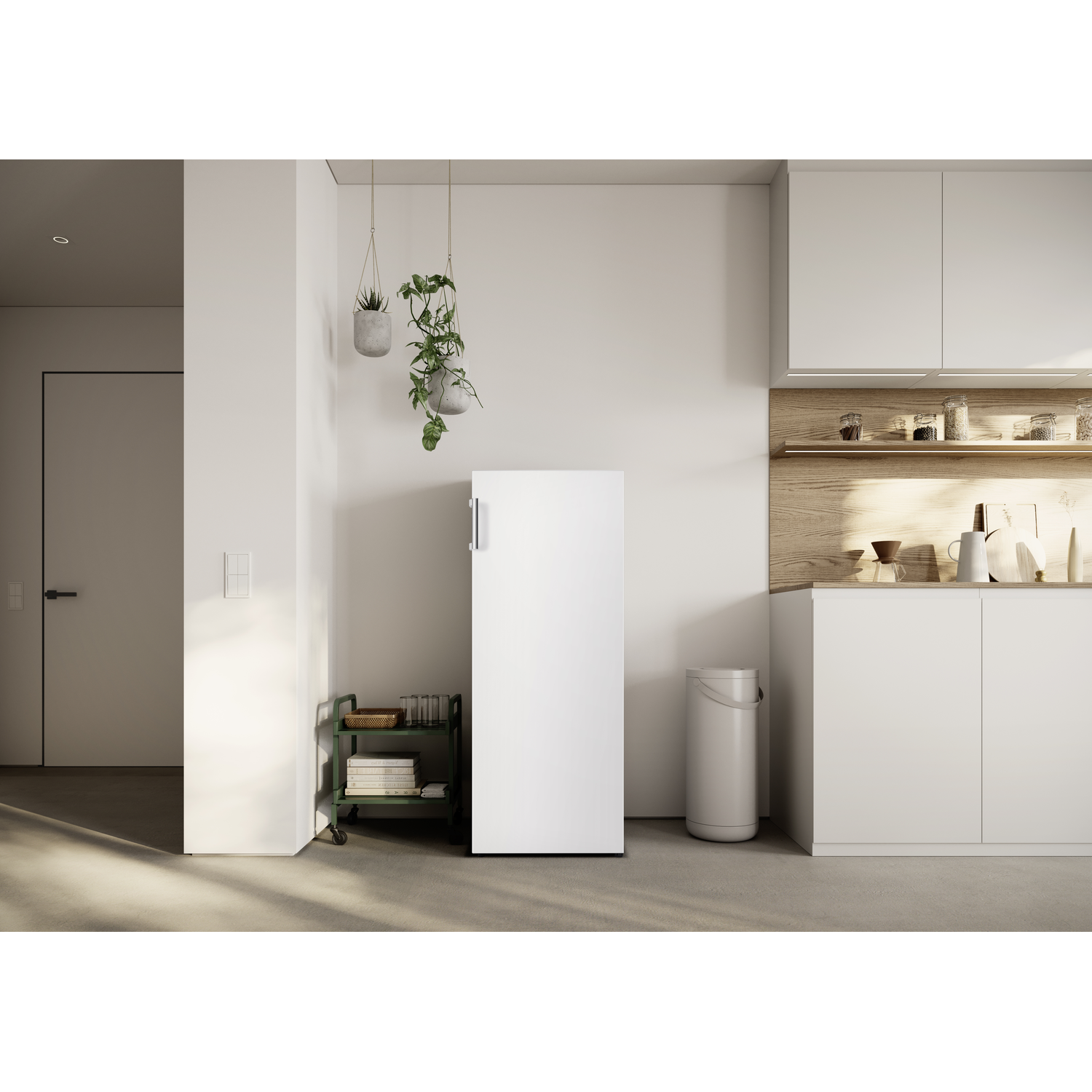 Modern kitchen with white fridge, cabinets, and a rolling cart with books.