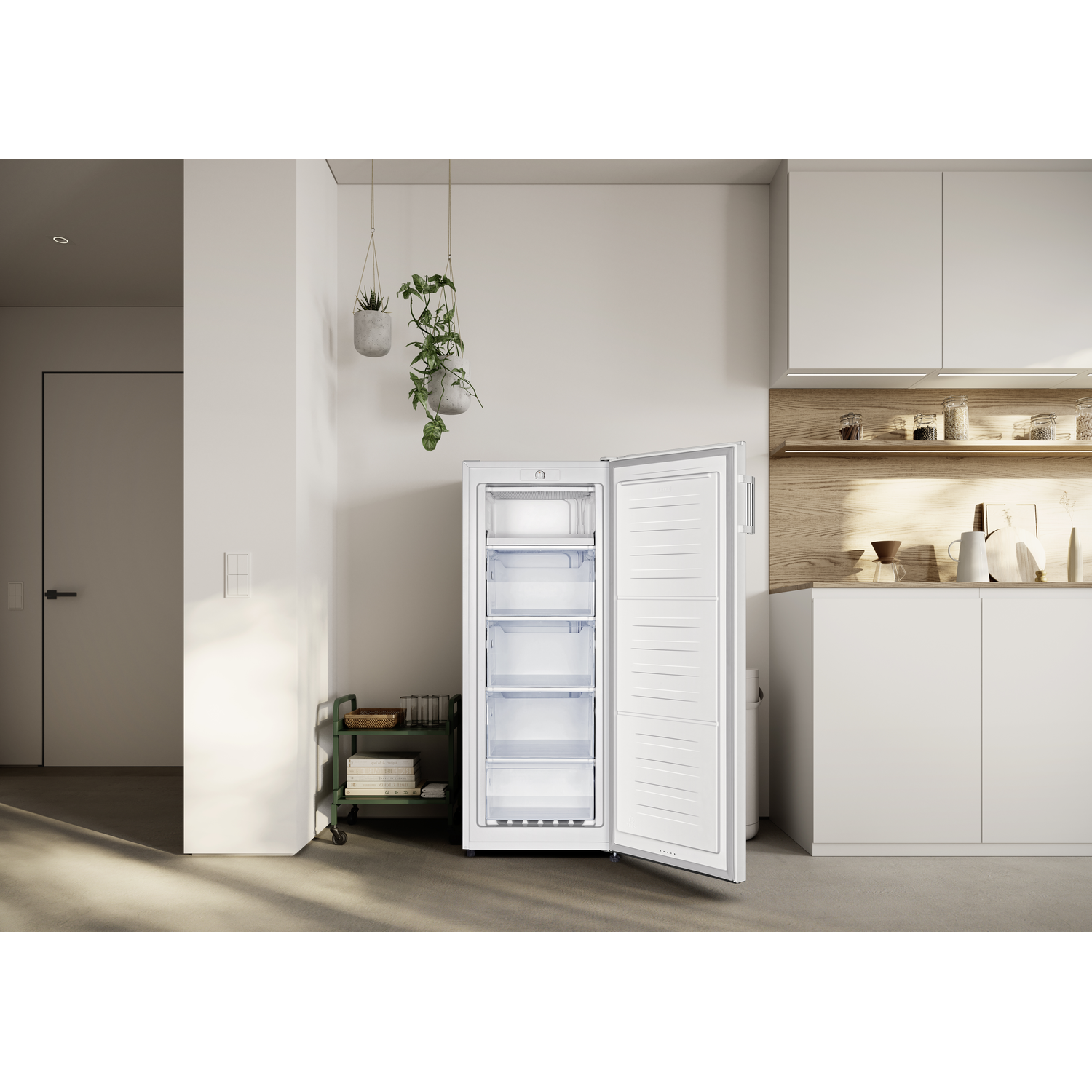 An open white freezer stands in a modern kitchen with hanging plants.