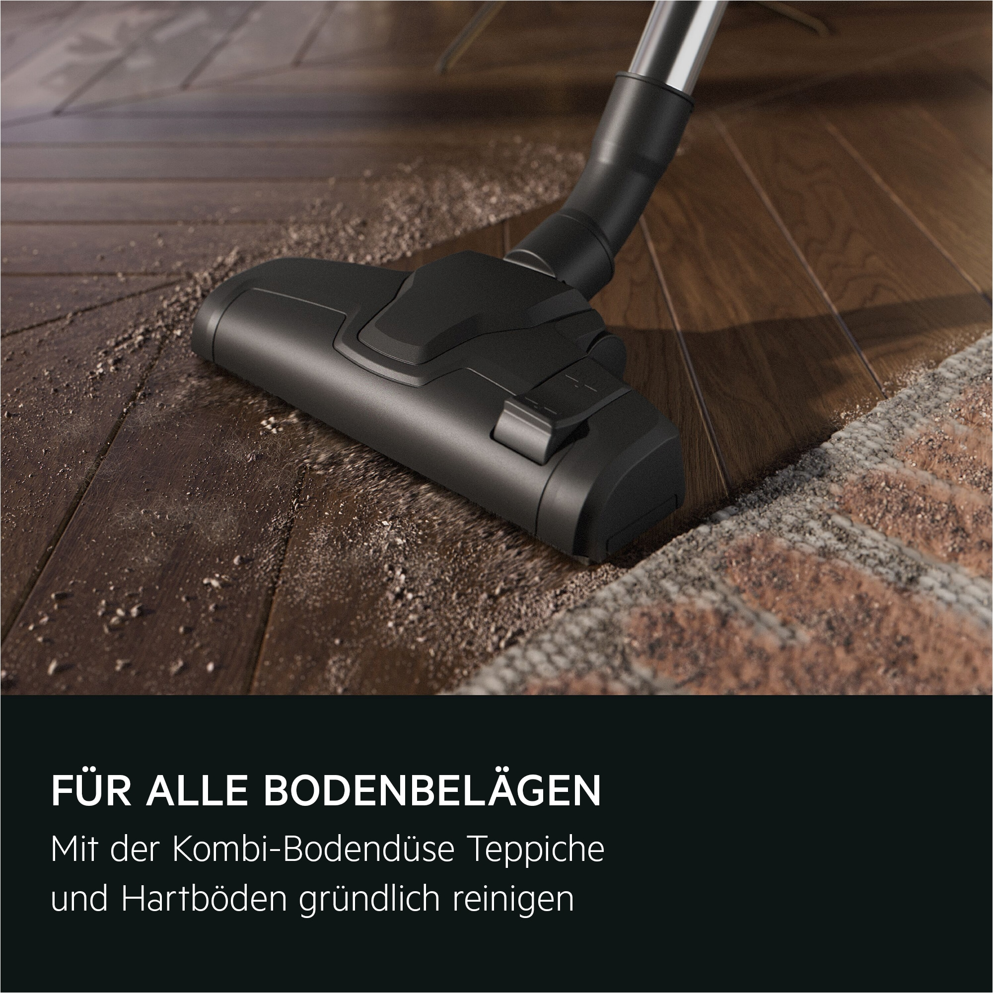 Ein schwarzer Staubsaugerkopf reinigt einen Holzboden und einen Teppich von Schmutz.