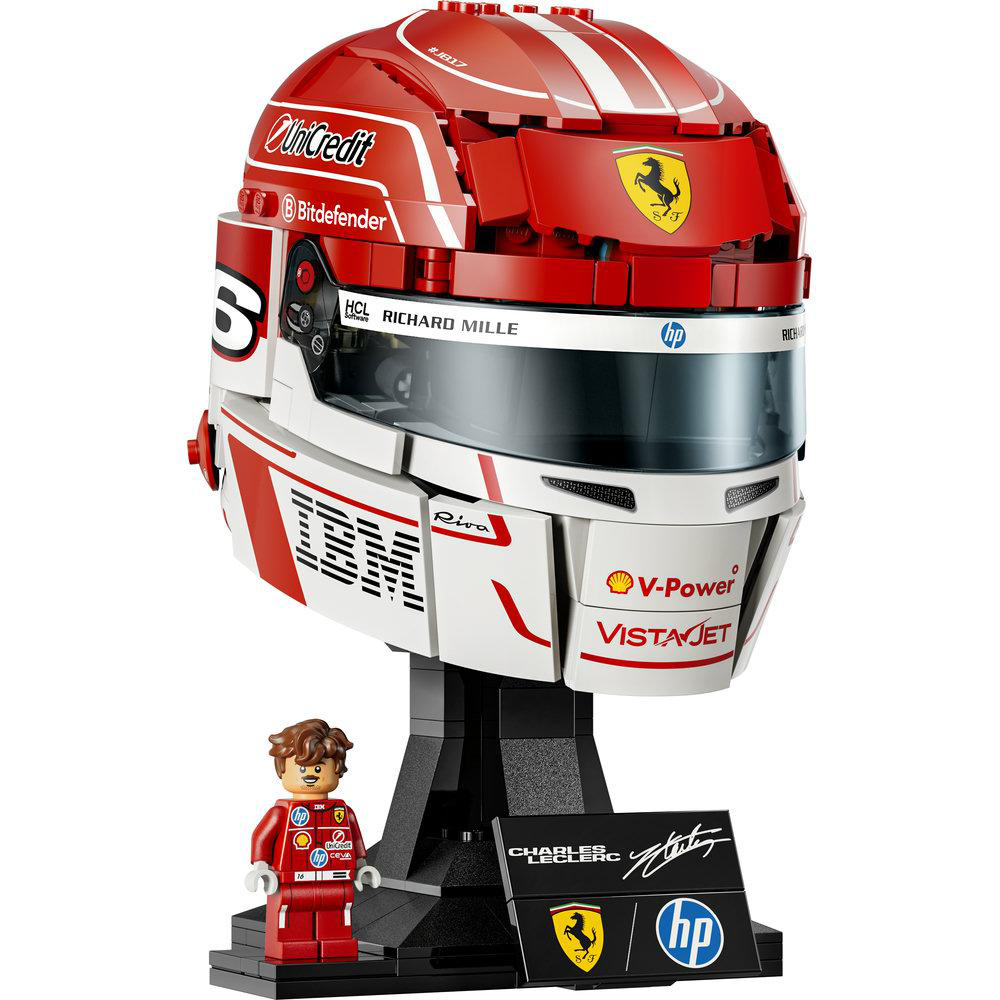 Ein roter und weißer Formel-1-Helm aus Lego auf einem Ständer mit einer Minifigur daneben.