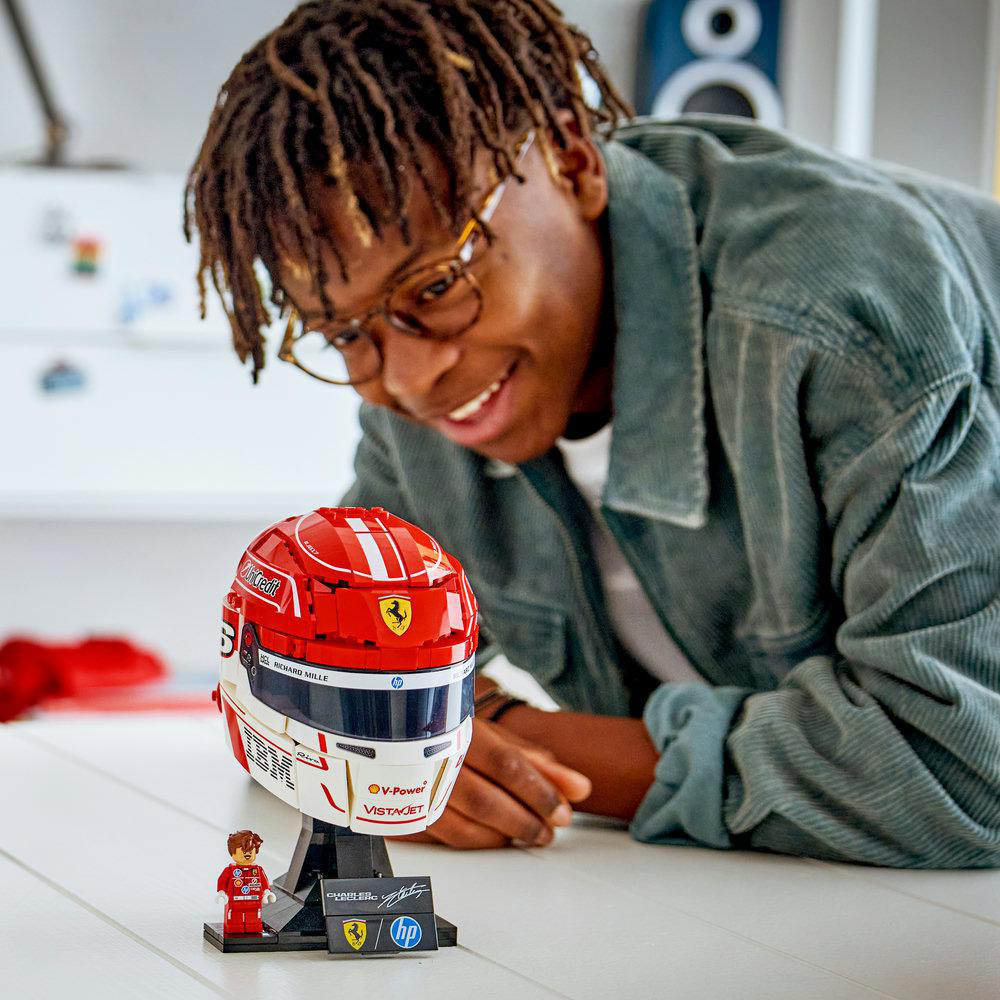Ein Mann schaut auf einen roten Lego-Helm mit Ferrari-Aufklebern.