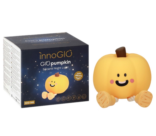 Żółta lampka nocna w kształcie dyni obok opakowania.