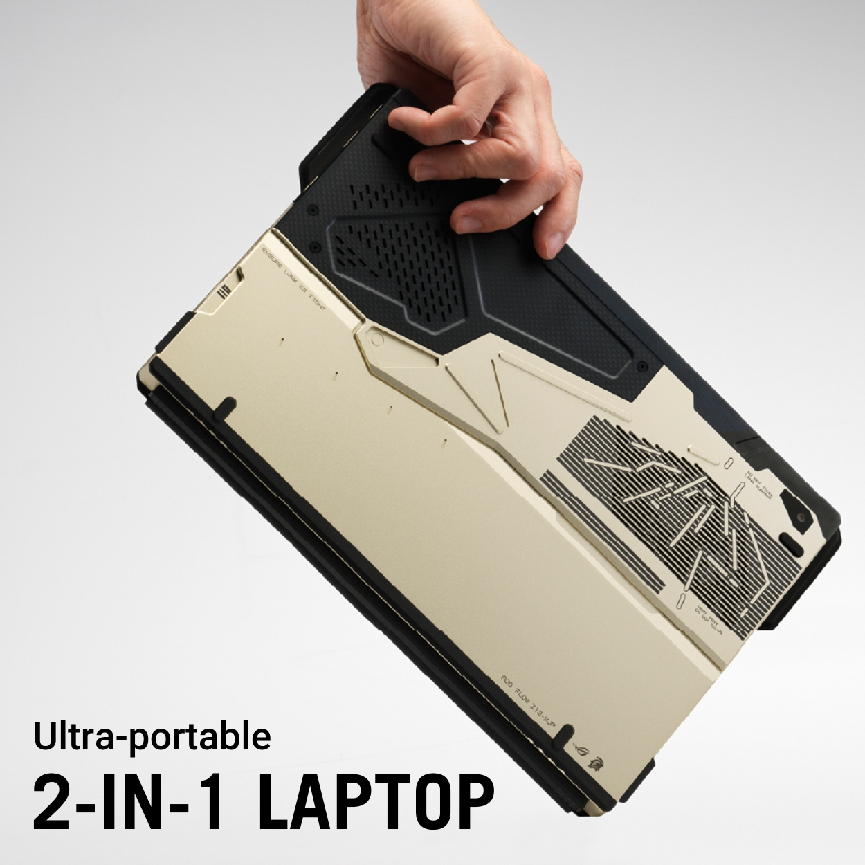 Eine Hand hält einen beige-schwarzen 2-in-1-Laptop mit aufgedruckten Details.